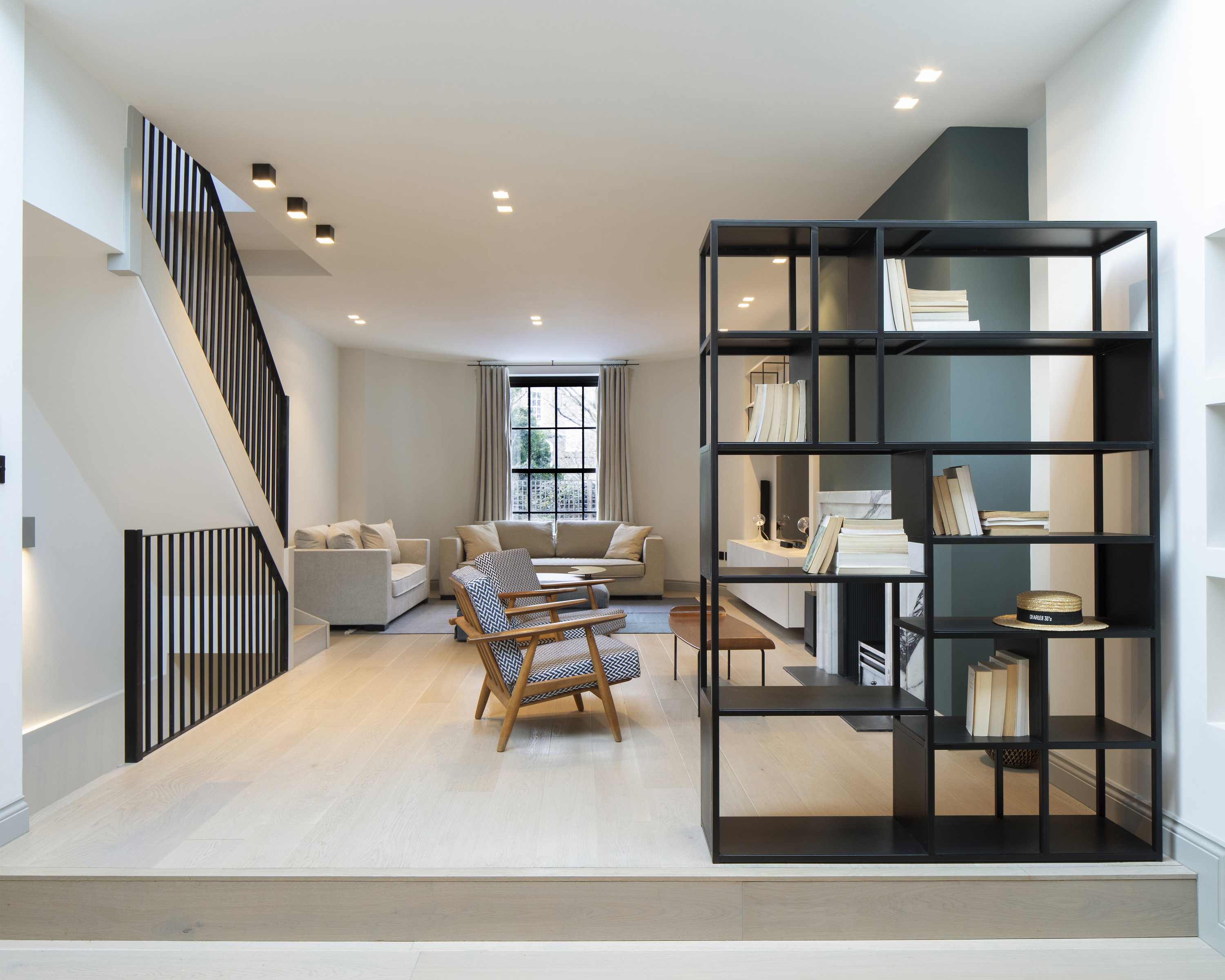 Open plan living room with bespoke metal staircase rail and shelving