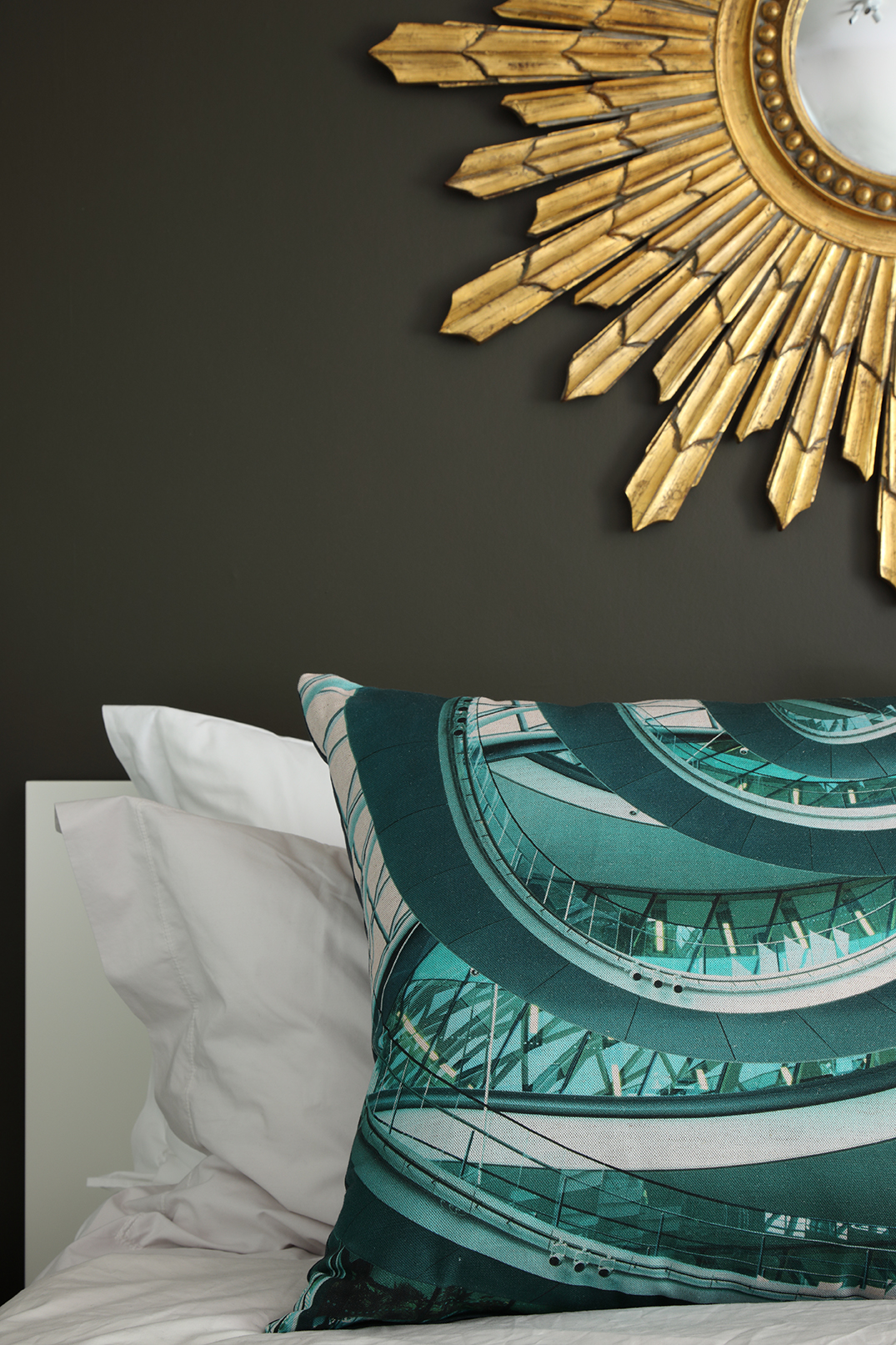 Cushion in shades of teal and turquoise printed with image of the spiral walkway at London's former City Hall