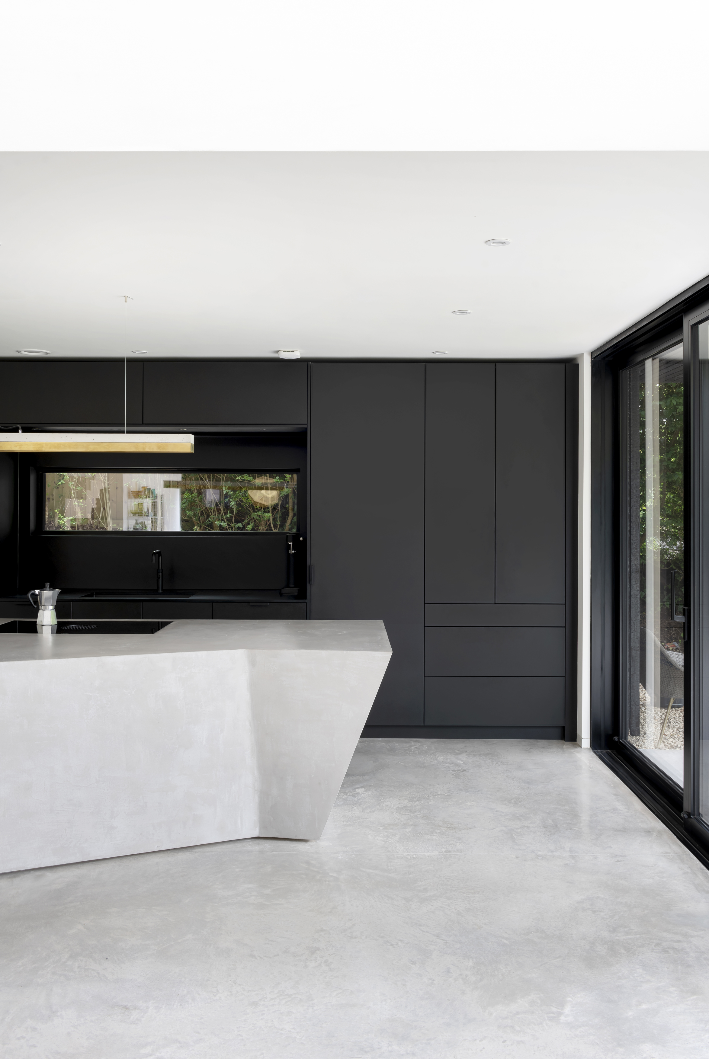 Bespoke Richlite clad kitchen, Origami concrete island, sliding black patio doors to garden