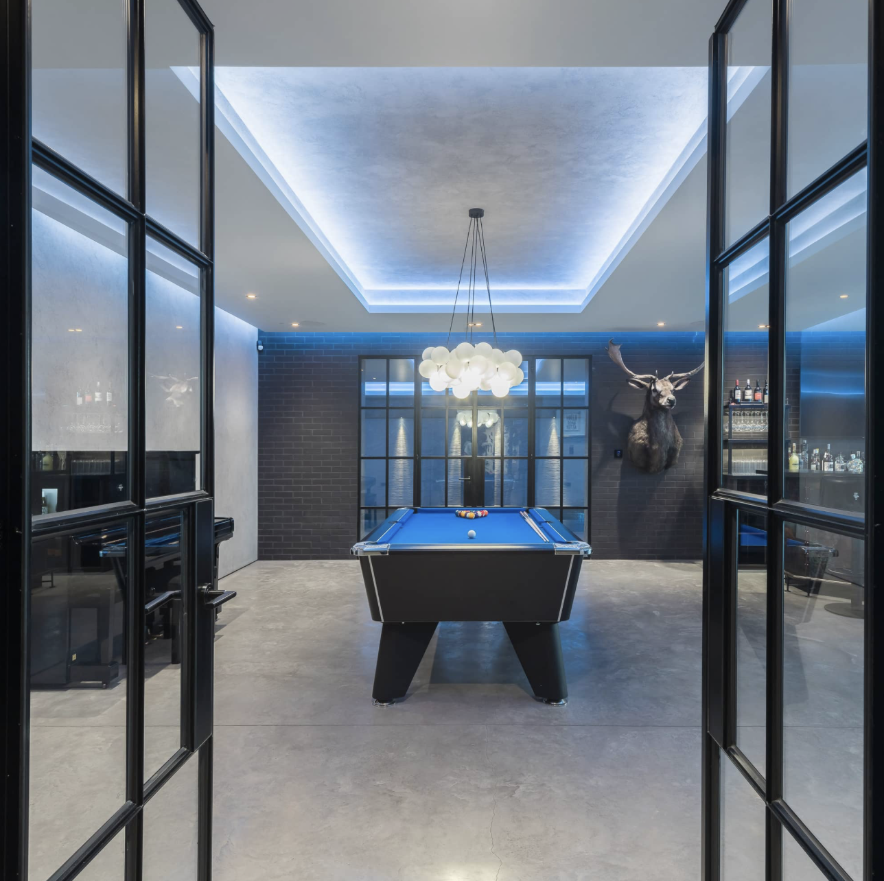 Entrance to sports bar via Crittall doors and concrete floor