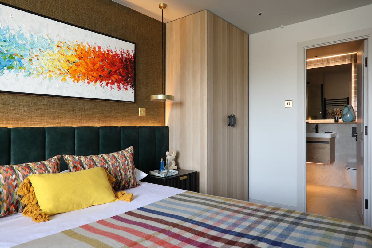 A view of the bedroom with a rainbow picture on the wall