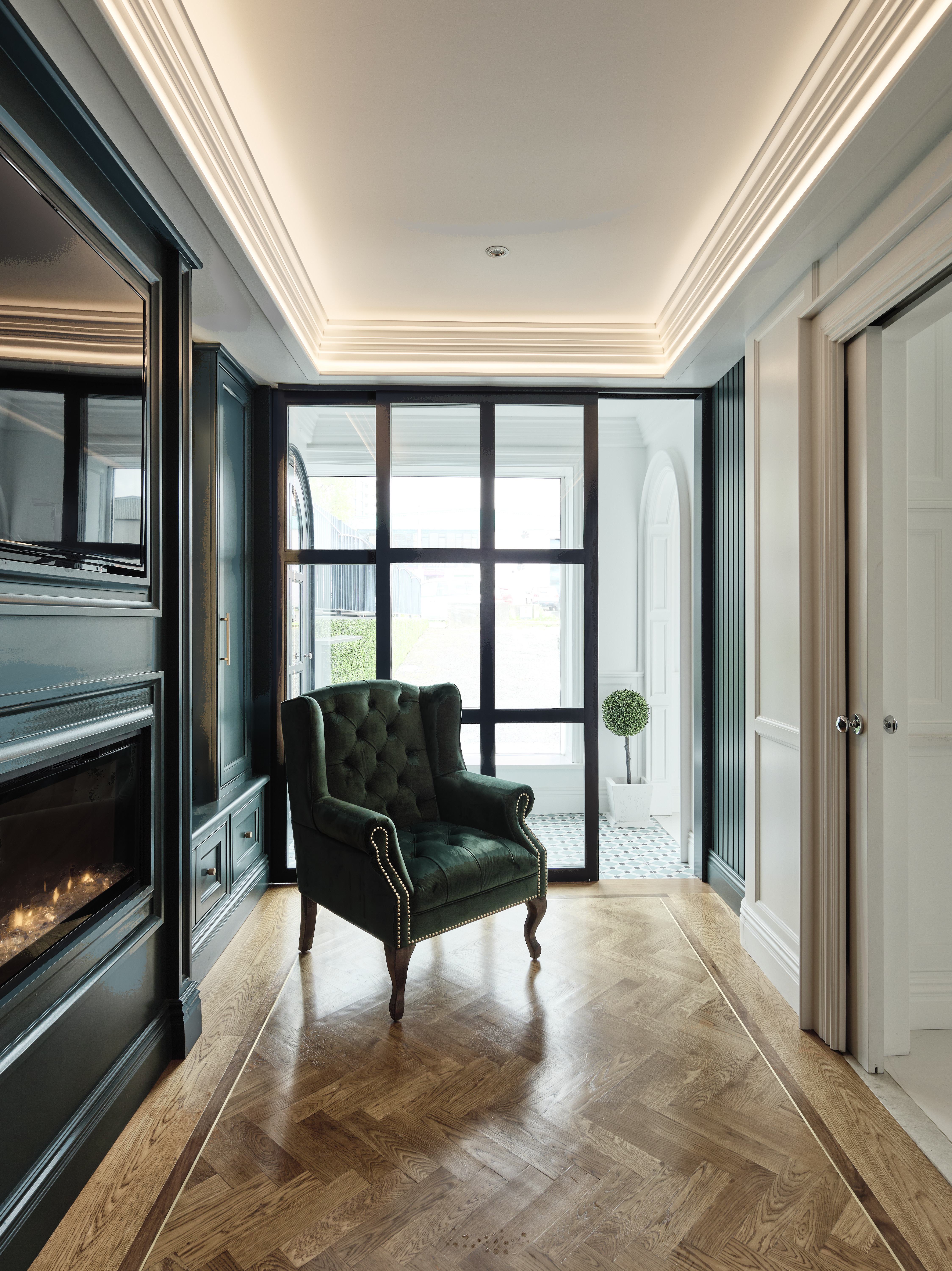 Beautiul snug area with crafted American oak herringbone floor, media unit and wooden crittall style sliding door. 