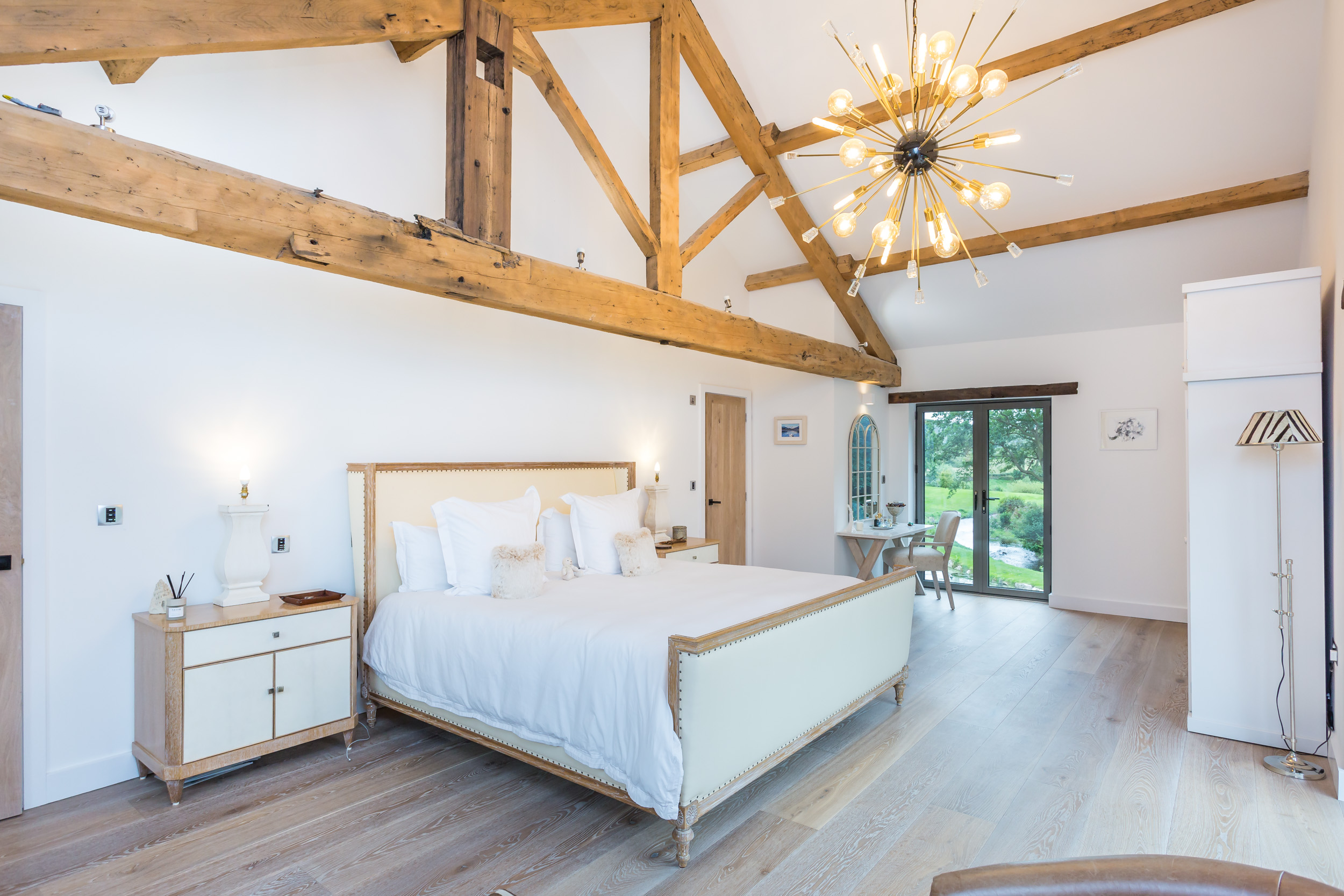 Light and bright Master Bedroom, with exposed beams, and view out to the millpond.