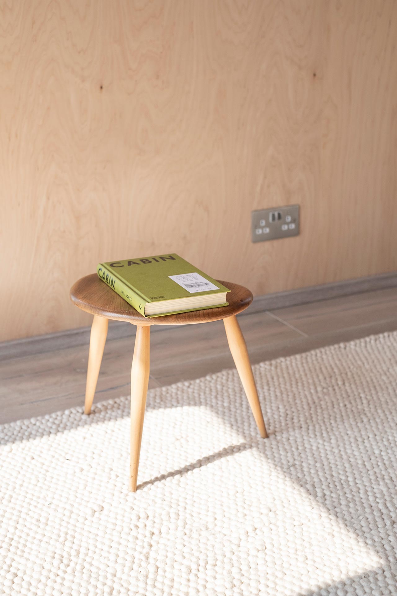 Minimal style stool with book and rug