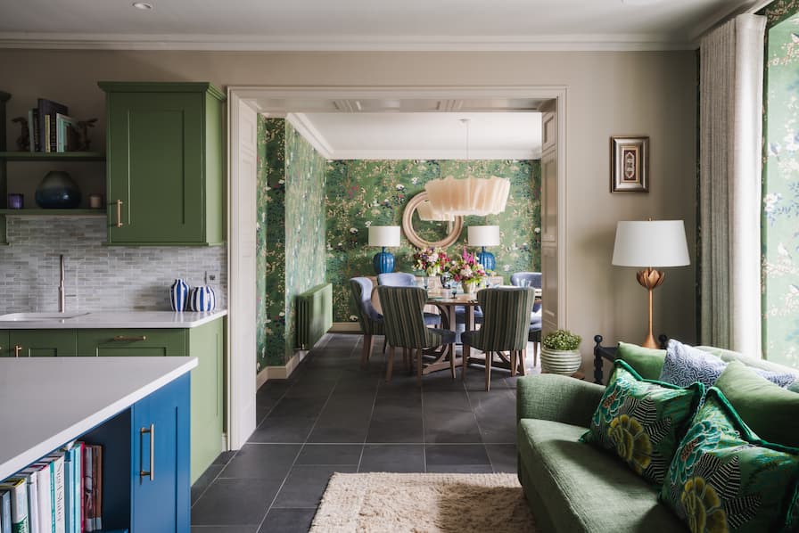 Colourful kitchen and dining area, with sofa covered in patterned scatter cushions