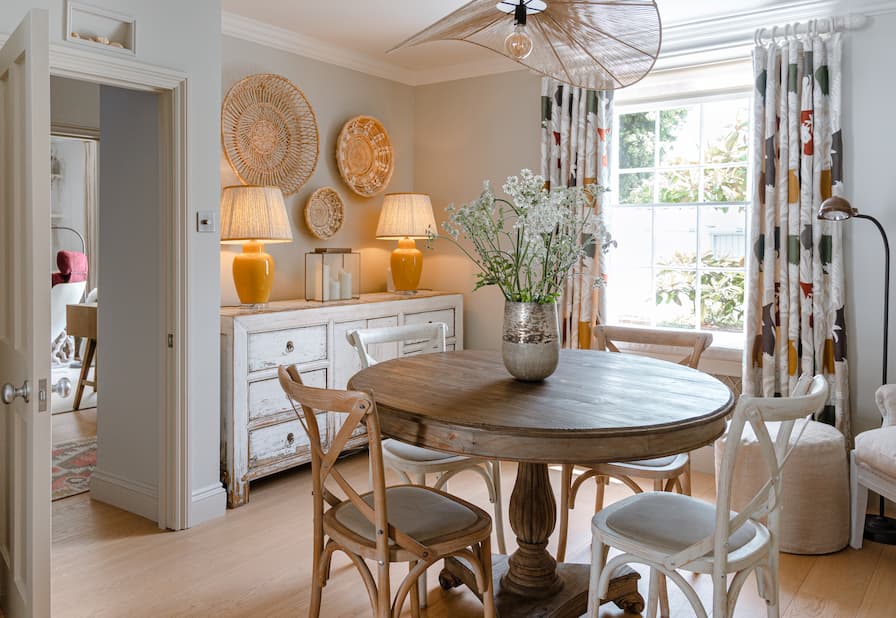 Cosy dining area space with wooden table and bright yellow table lamps