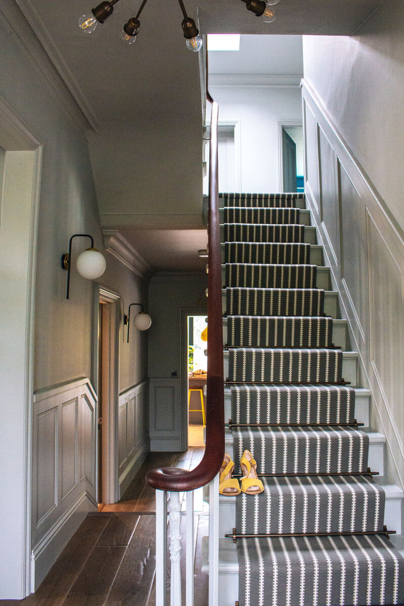 Staircase with striped runner and bespoke panelling