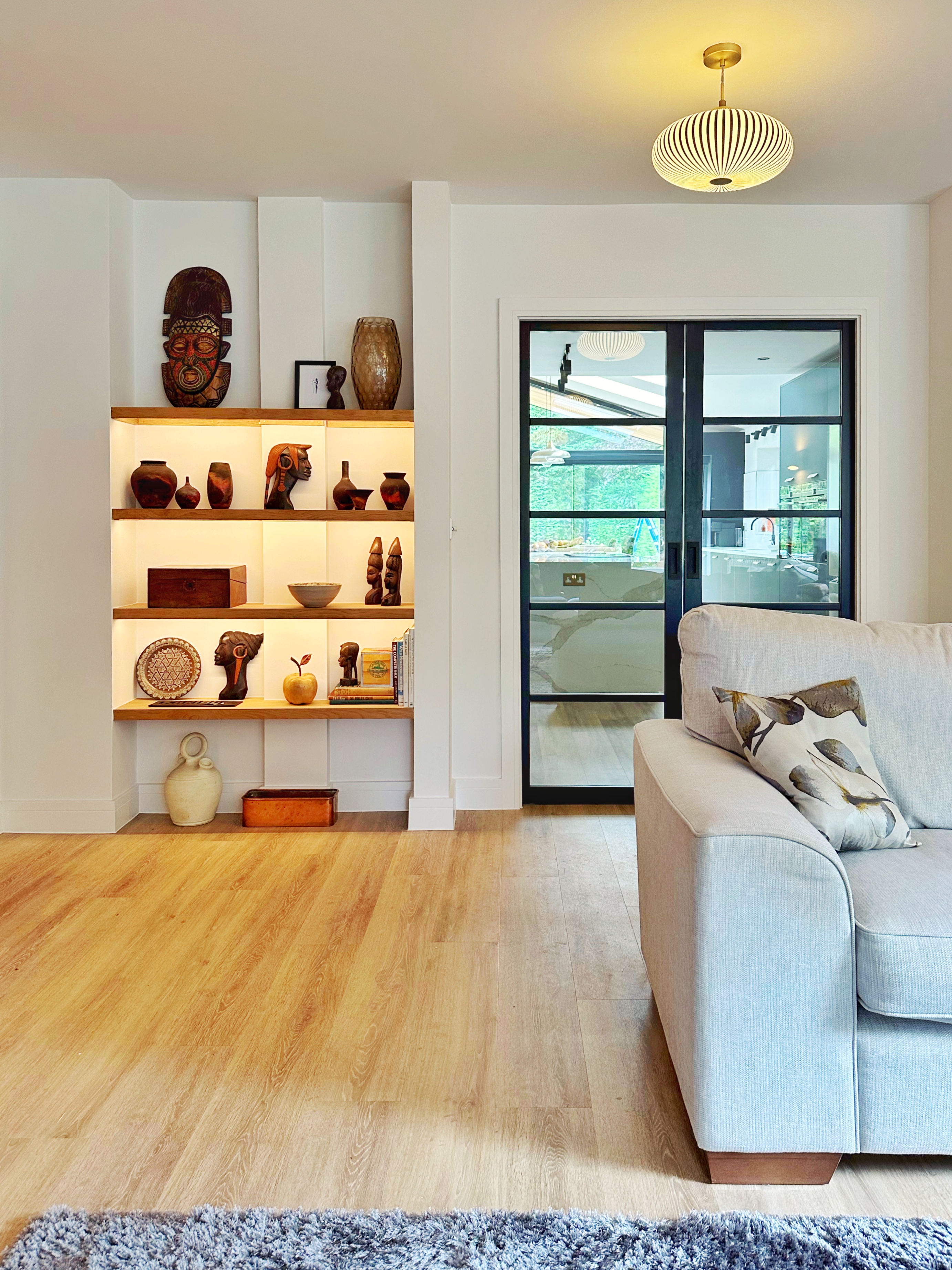 Back lit shelving and pocket doors leading through from the living room to the kitchen