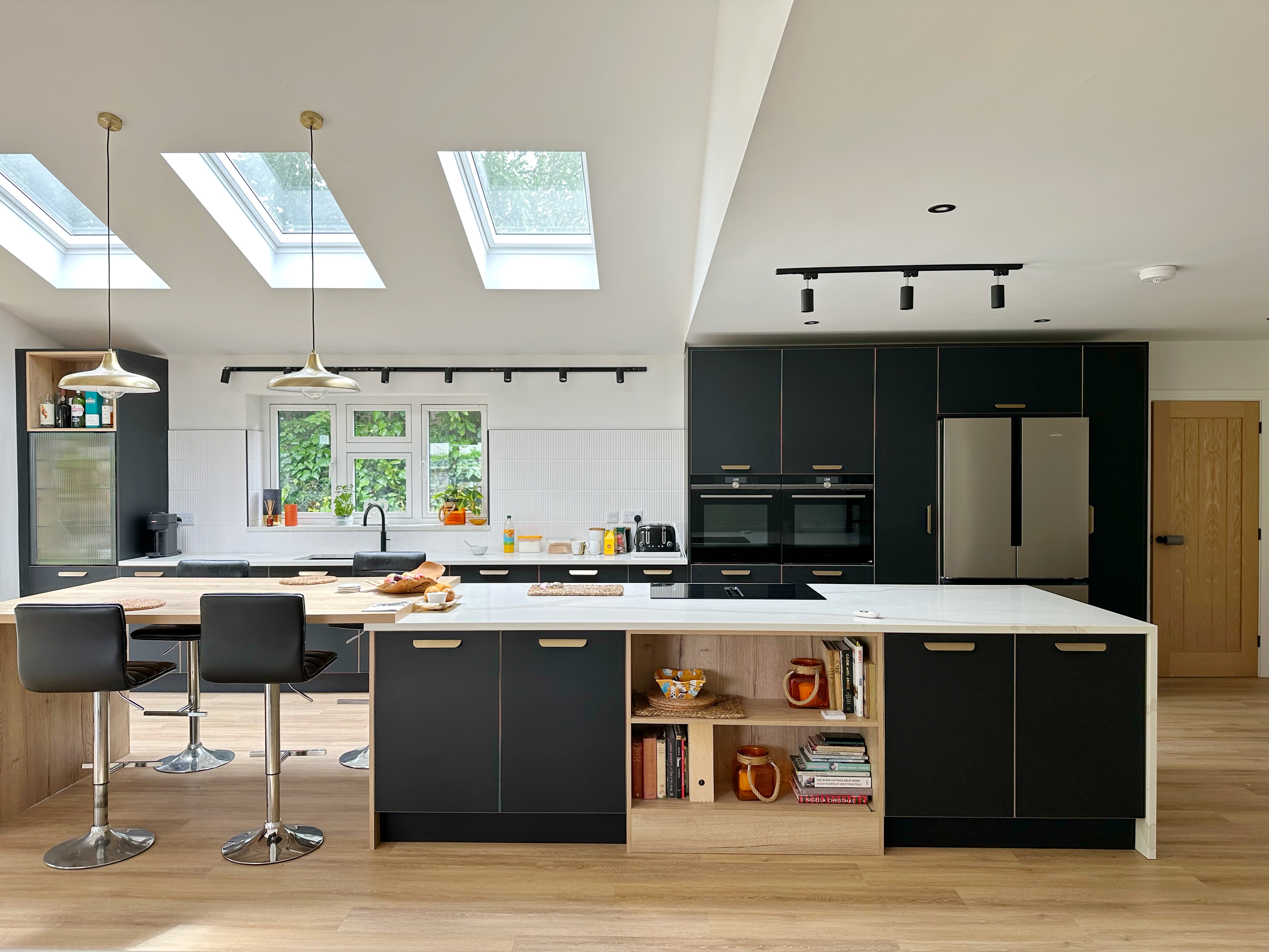 Black, marble and oak kitchen with a breakfast bar at the end of the island