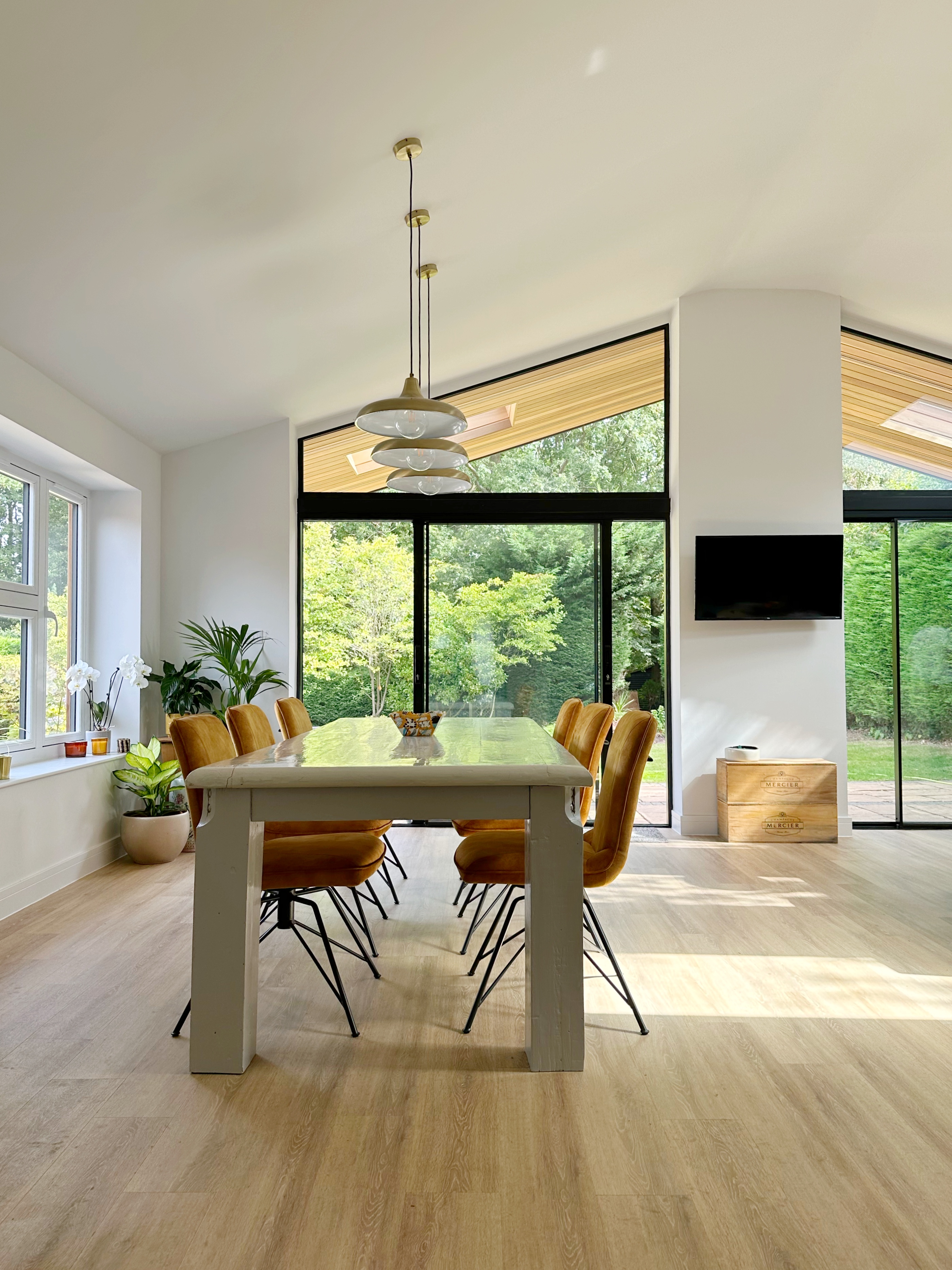 Dining table with pendant lighting above and full height glazing with views to the garden