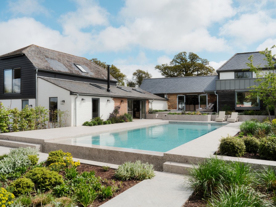 View of the back of the house, showing the large swimming pool and L Shape nature of the house.