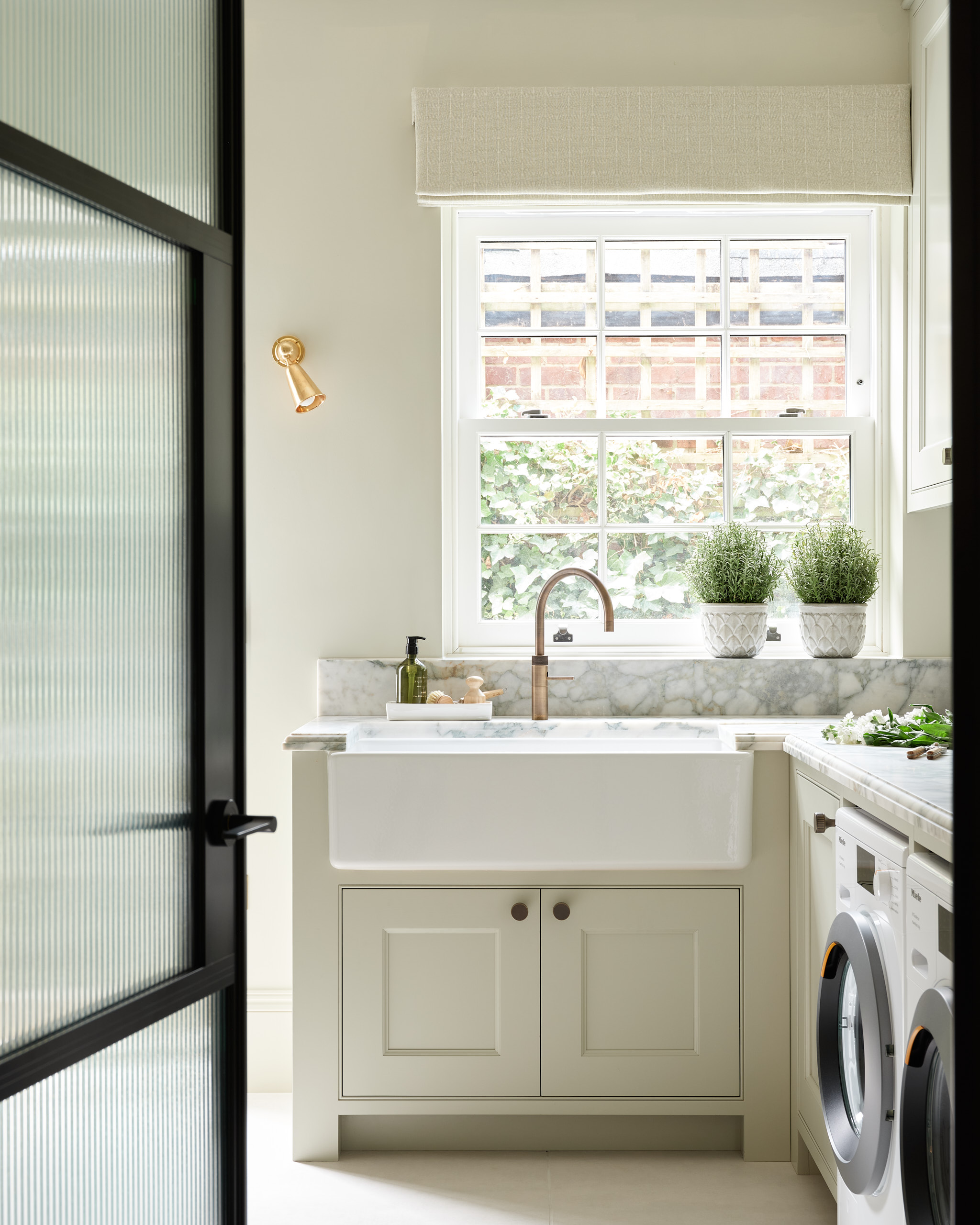 Green marble worktop and bespoke utility laundry joinery with crittall door access