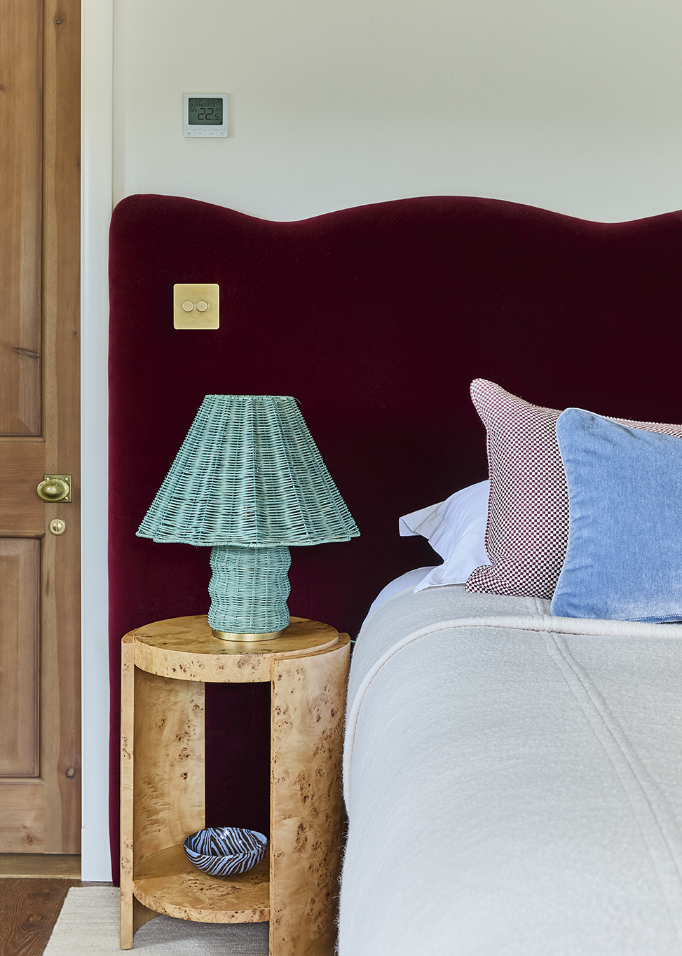 Guest bedroom with bold coloured, red headboard