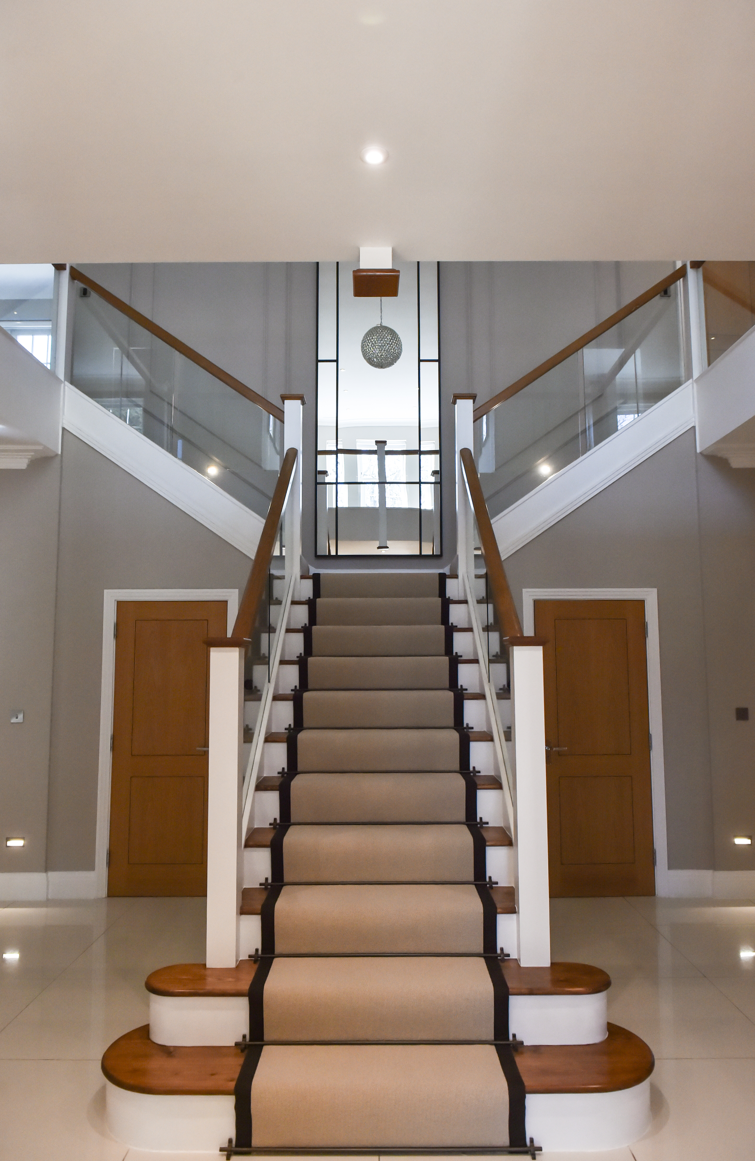 The existing carpet was removed, revealing the beautiful oak steps beneath. To accentuate the natural elegance, a sleek runner with dark edges was added, secured with dark bronze-finish rods, offering a stylish, tailored appearance.