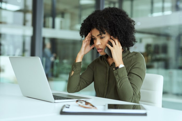 Woman at a laptop holding her head