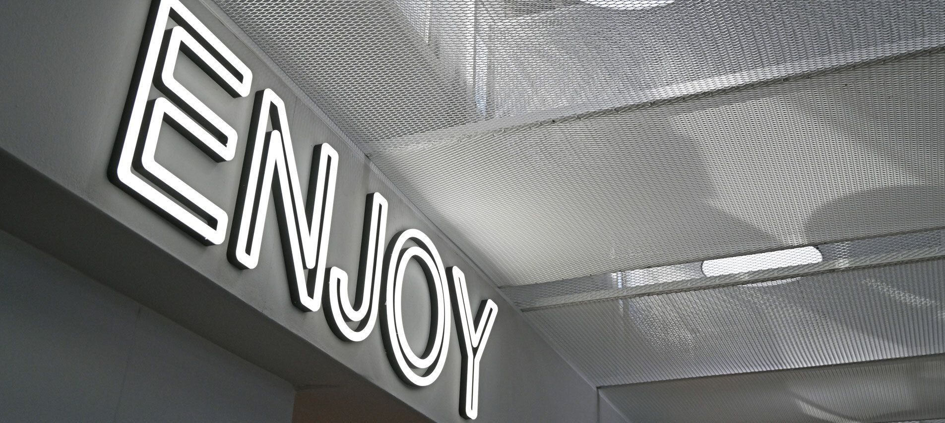 Ceiling with neon sign reading 'Enjoy'