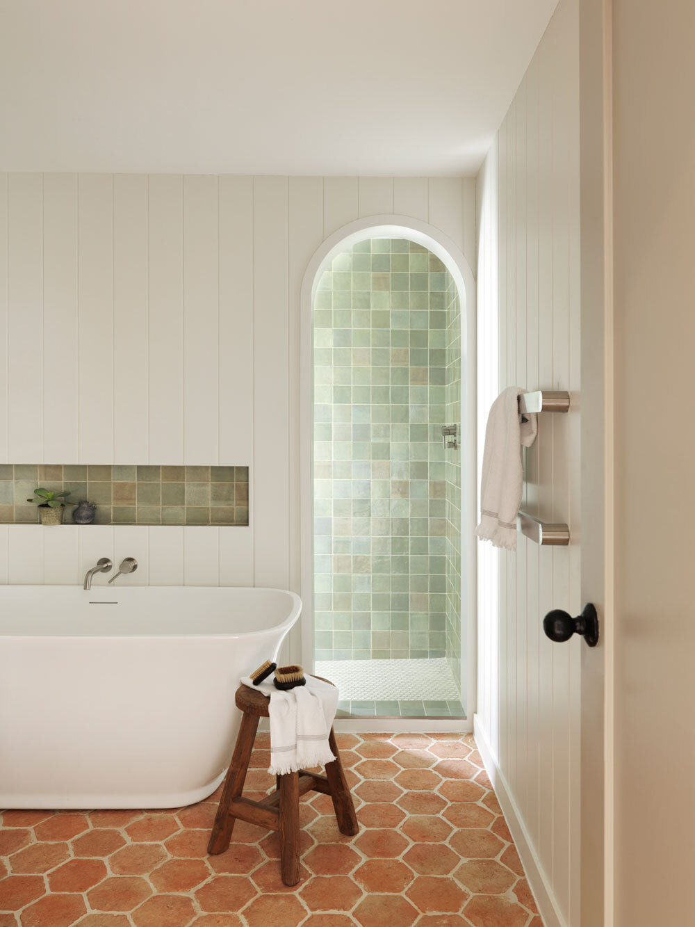 Bathroom with bath and shower in arch