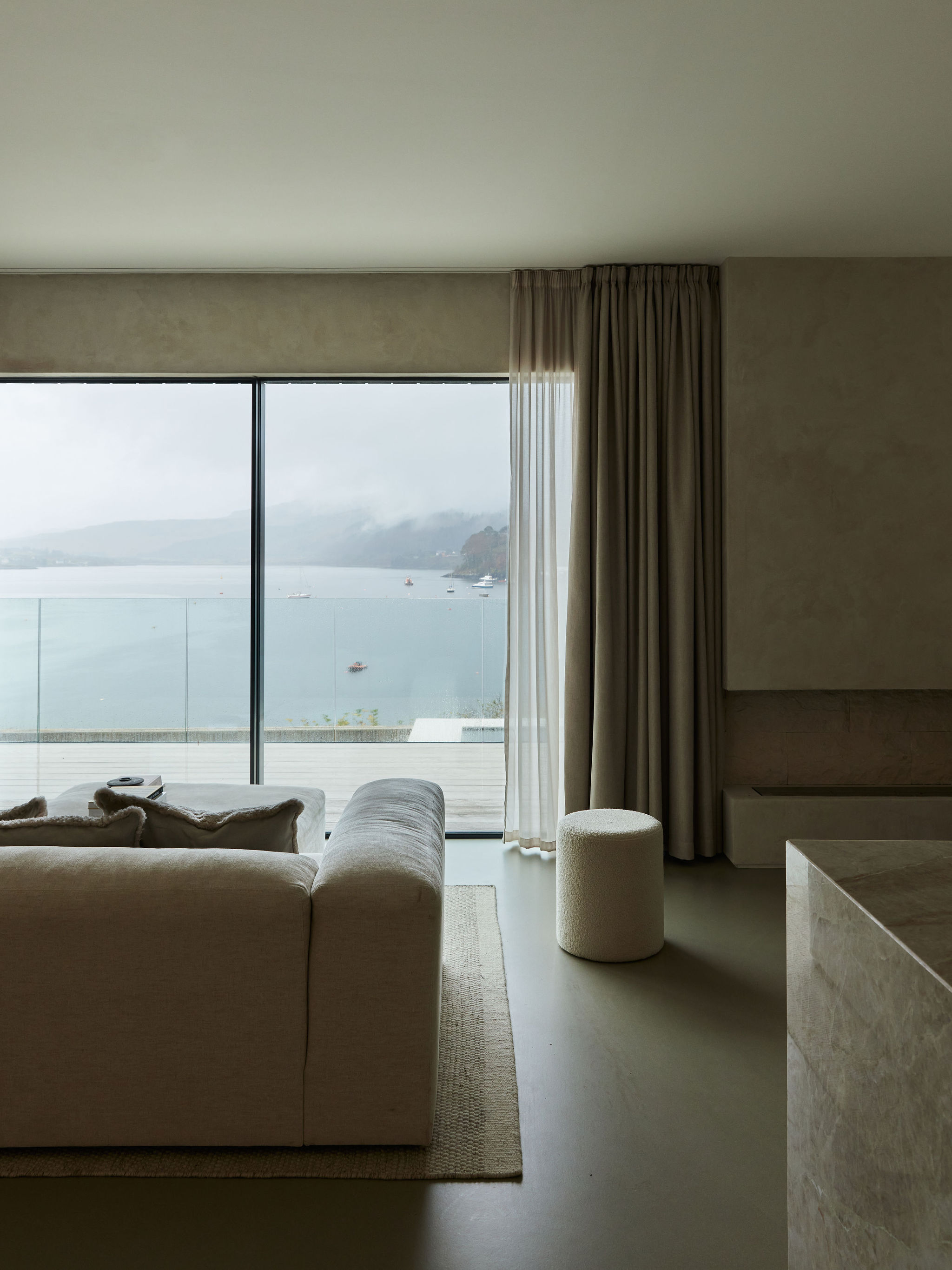 Sofa looking out onto window with view of lake