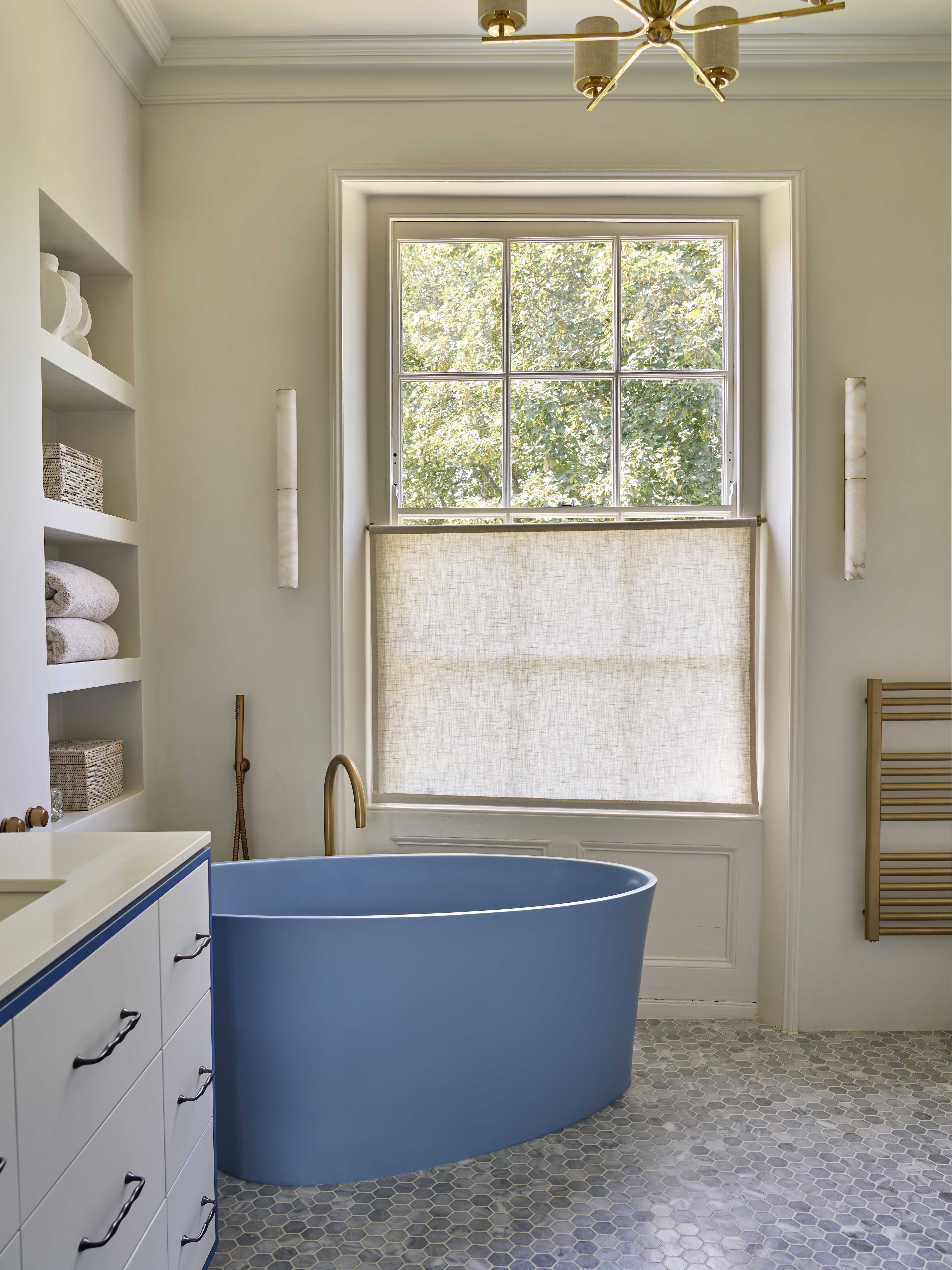 A blue freestanding bath takes centre stage in this Primary Bathroom with tumbled blue mosaic floor and tadelakt walls. Original cornicing was kept throughout.