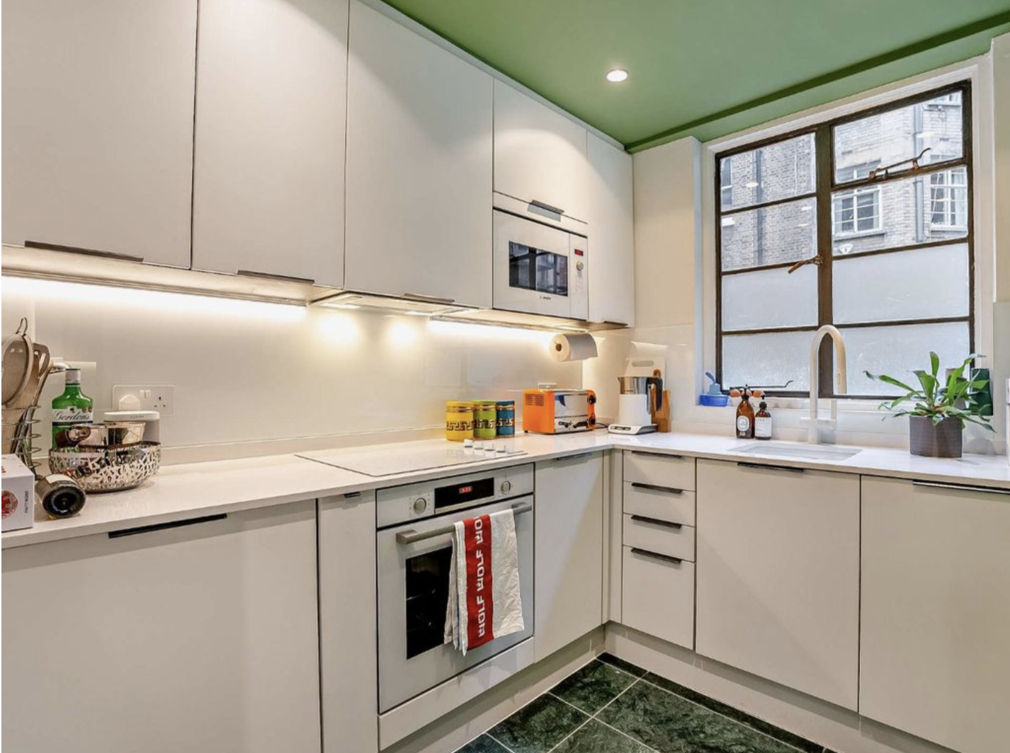 Kitchen with restored bronze window, Brazilian marble floor