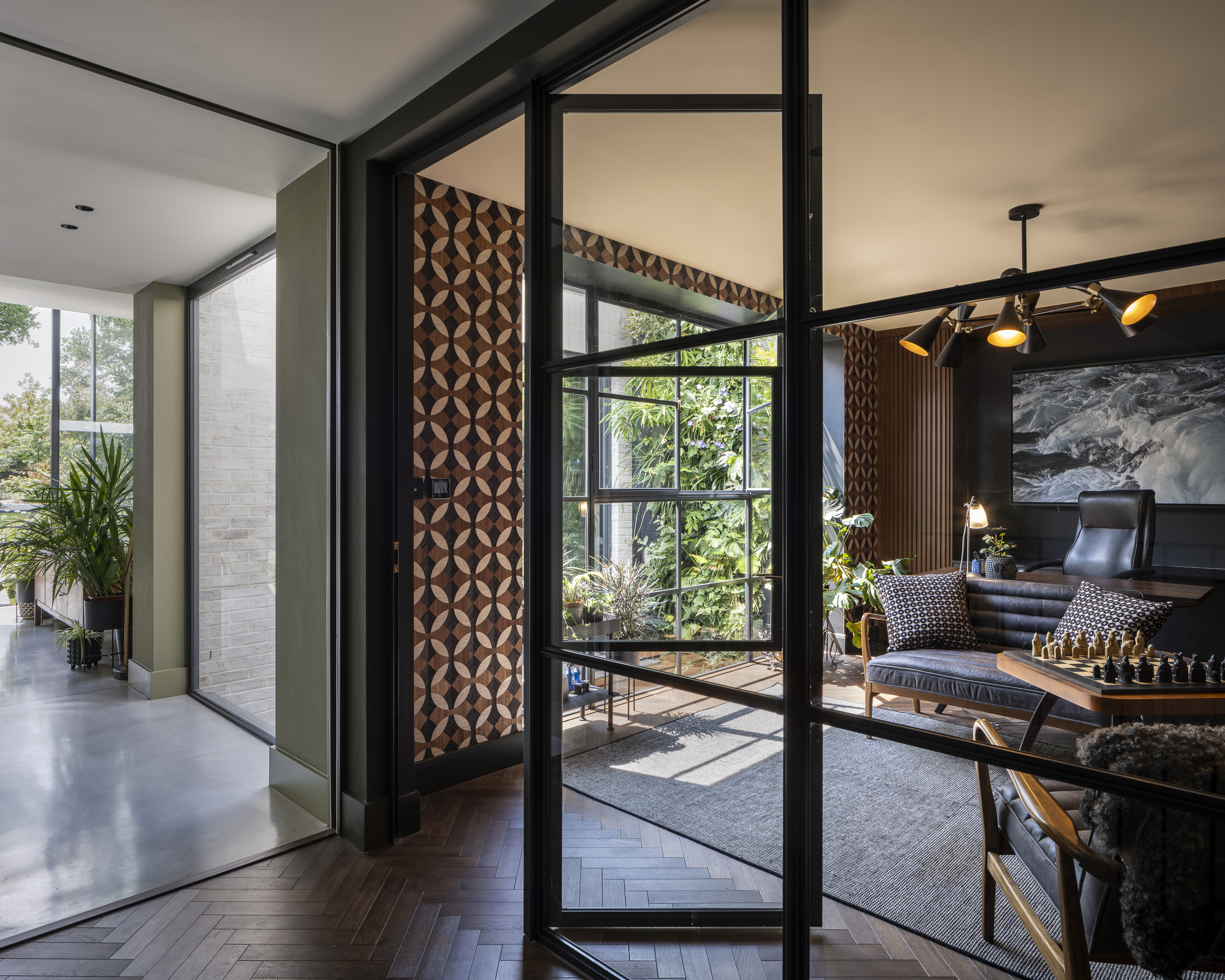 a view through a galzed wall  to the home office and the living wall beyond 