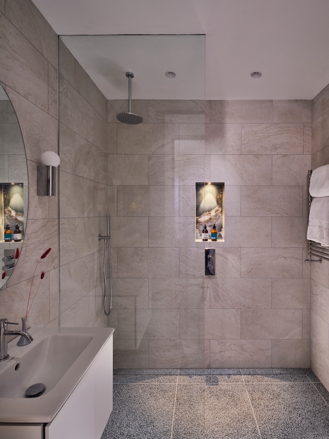 Compact shower room with terrazzo floors and travertine walls