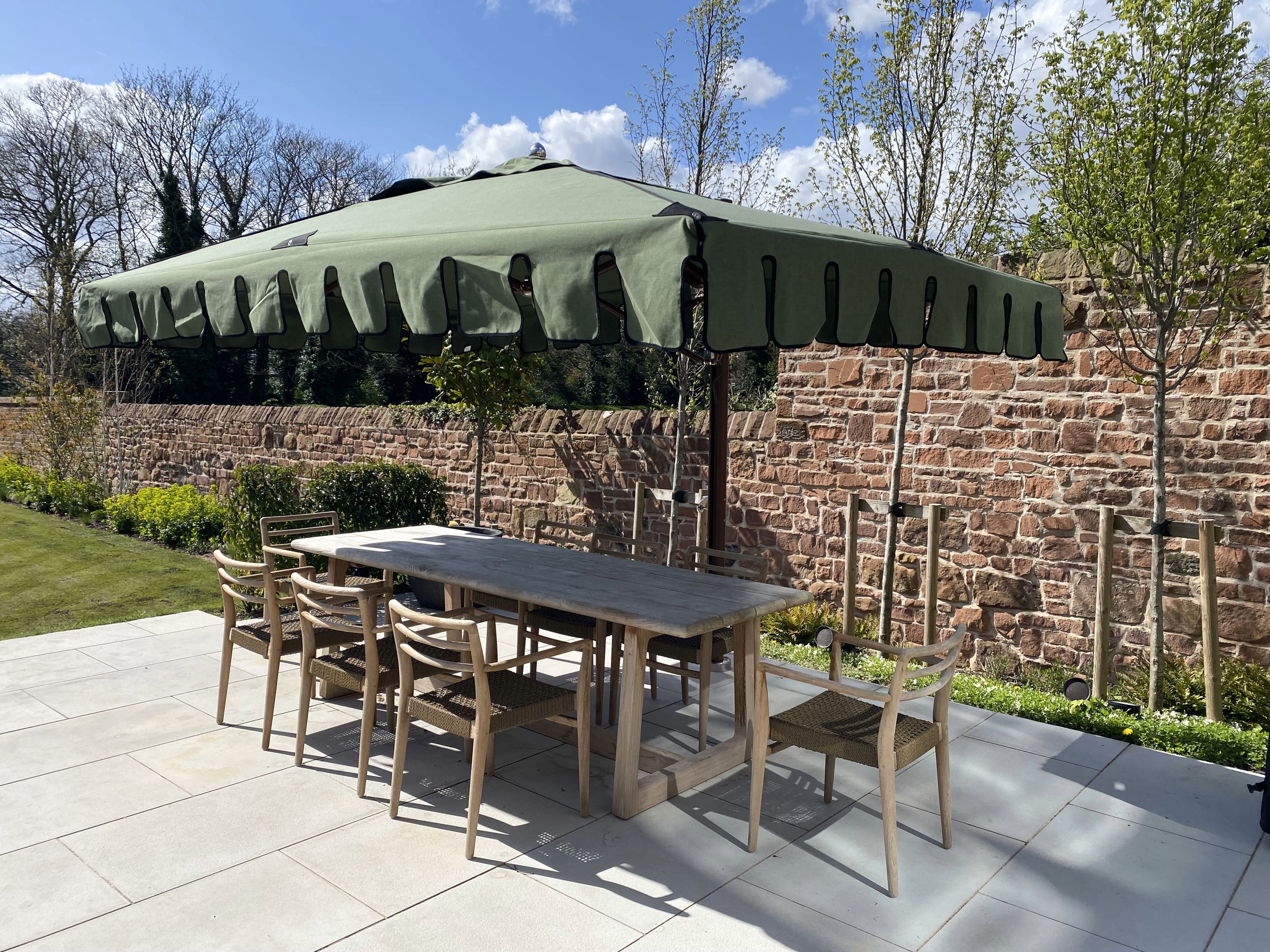 Image of Gommaire teak dining furniture beneath Tuuci Ocean Master Max luxury cantilever parasol