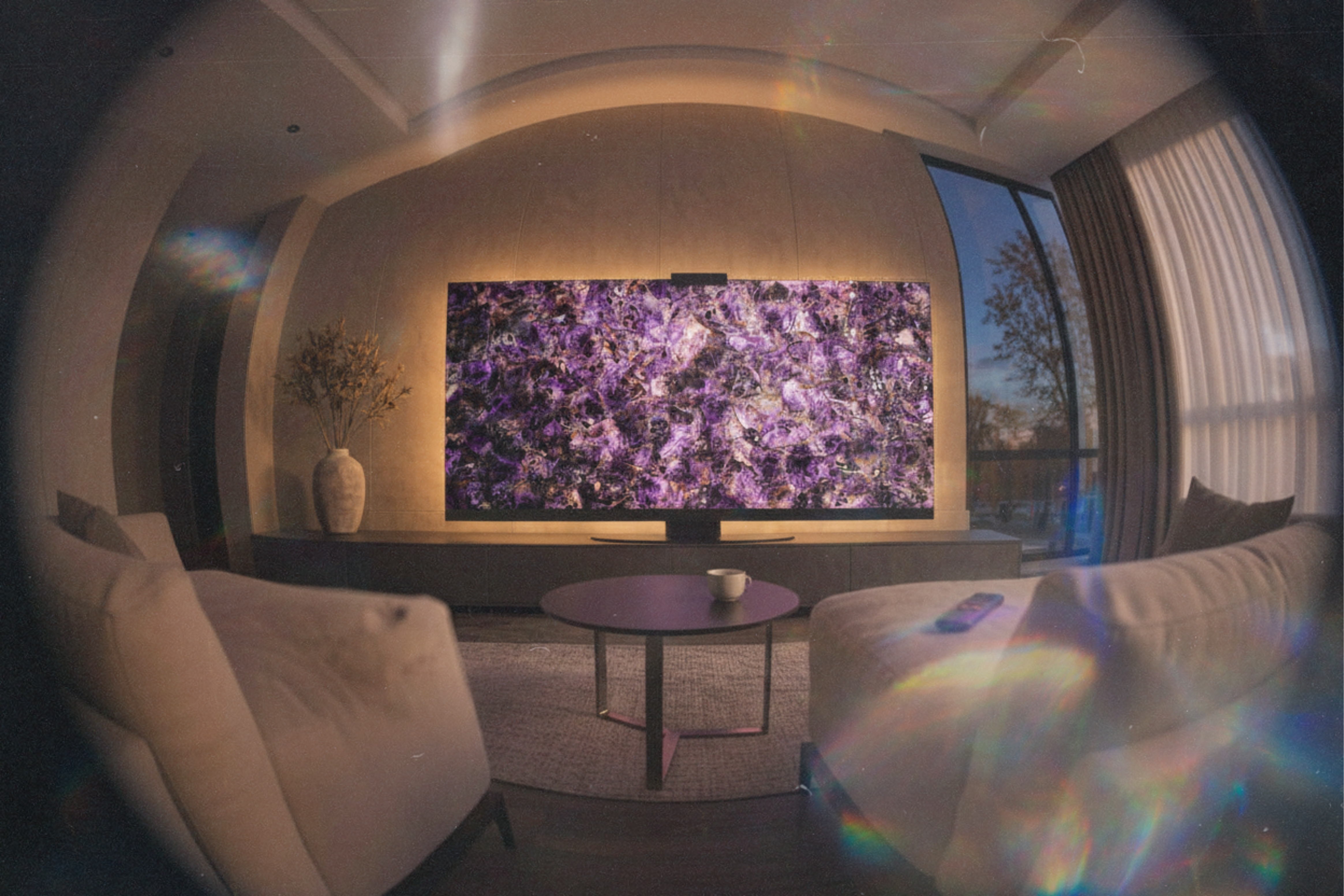 Amethyst Halo Screen at night with warm halo backlight, luminous violet crystal depth, and a sculptural gemstone presence in a moody living room.