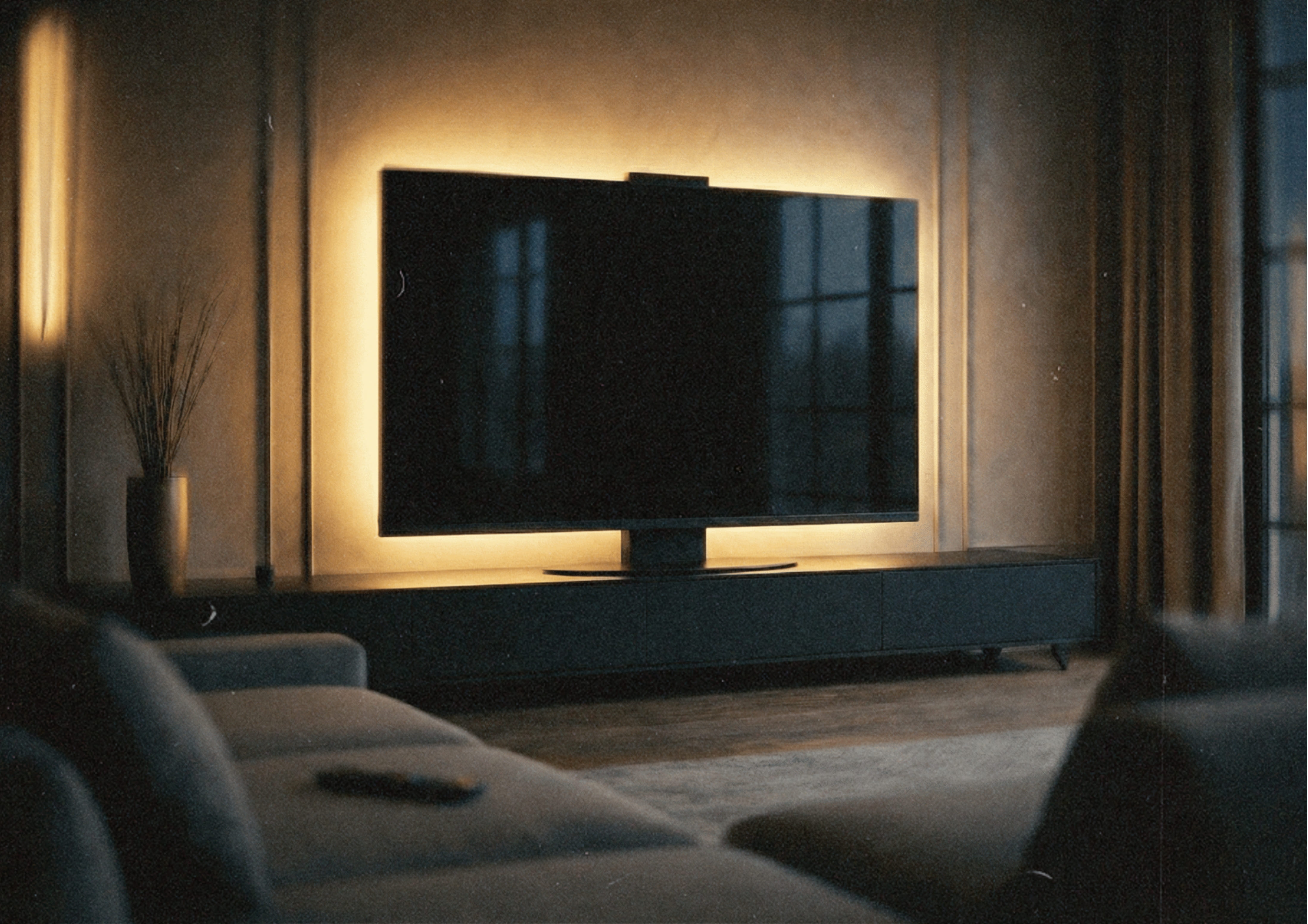 Halo Screen in Nero Assoluto granite with warm halo backlight in a dark modern living room