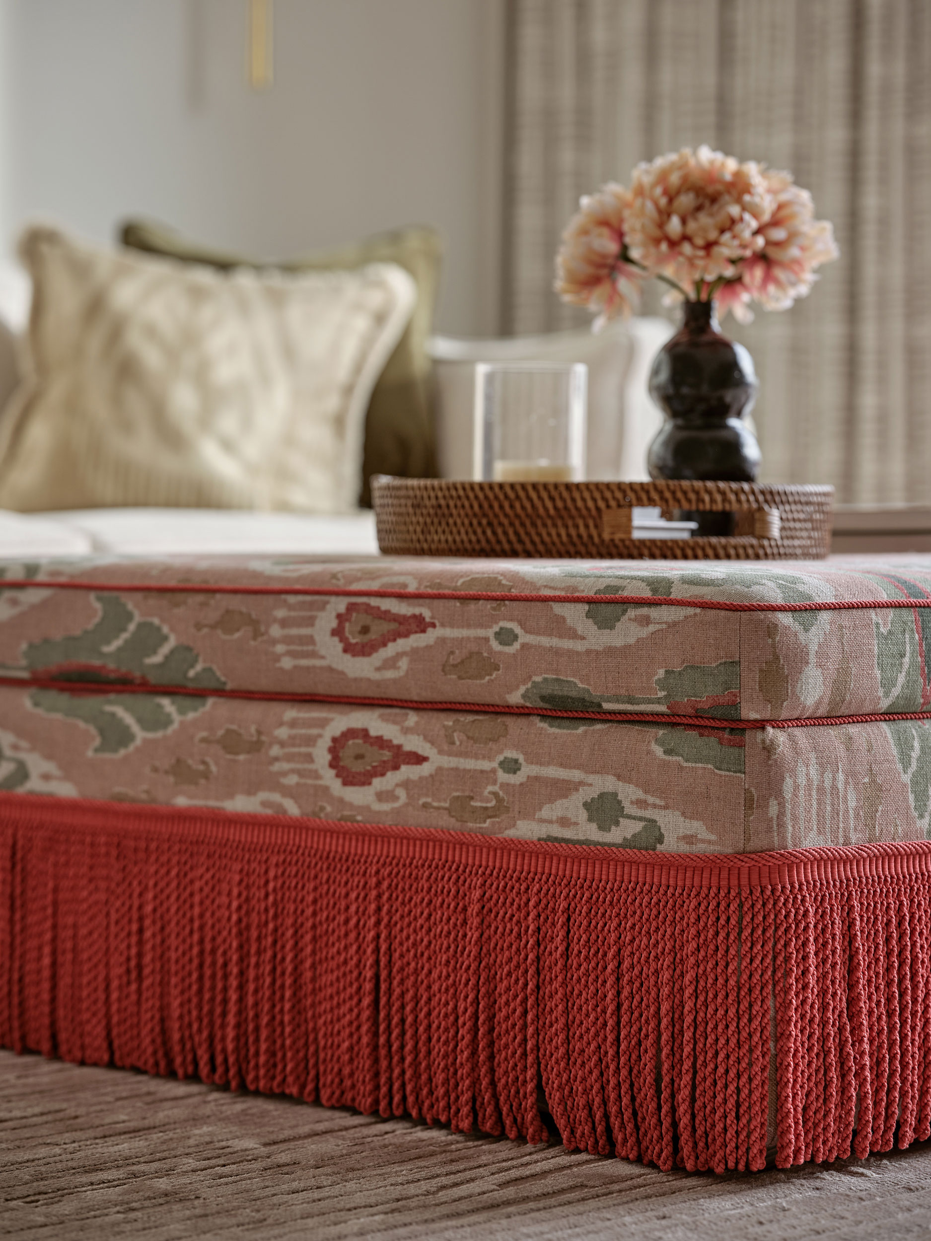 Bespoke ottoman with recessed tray, bold upholstery and pink fringing made by Origins Design