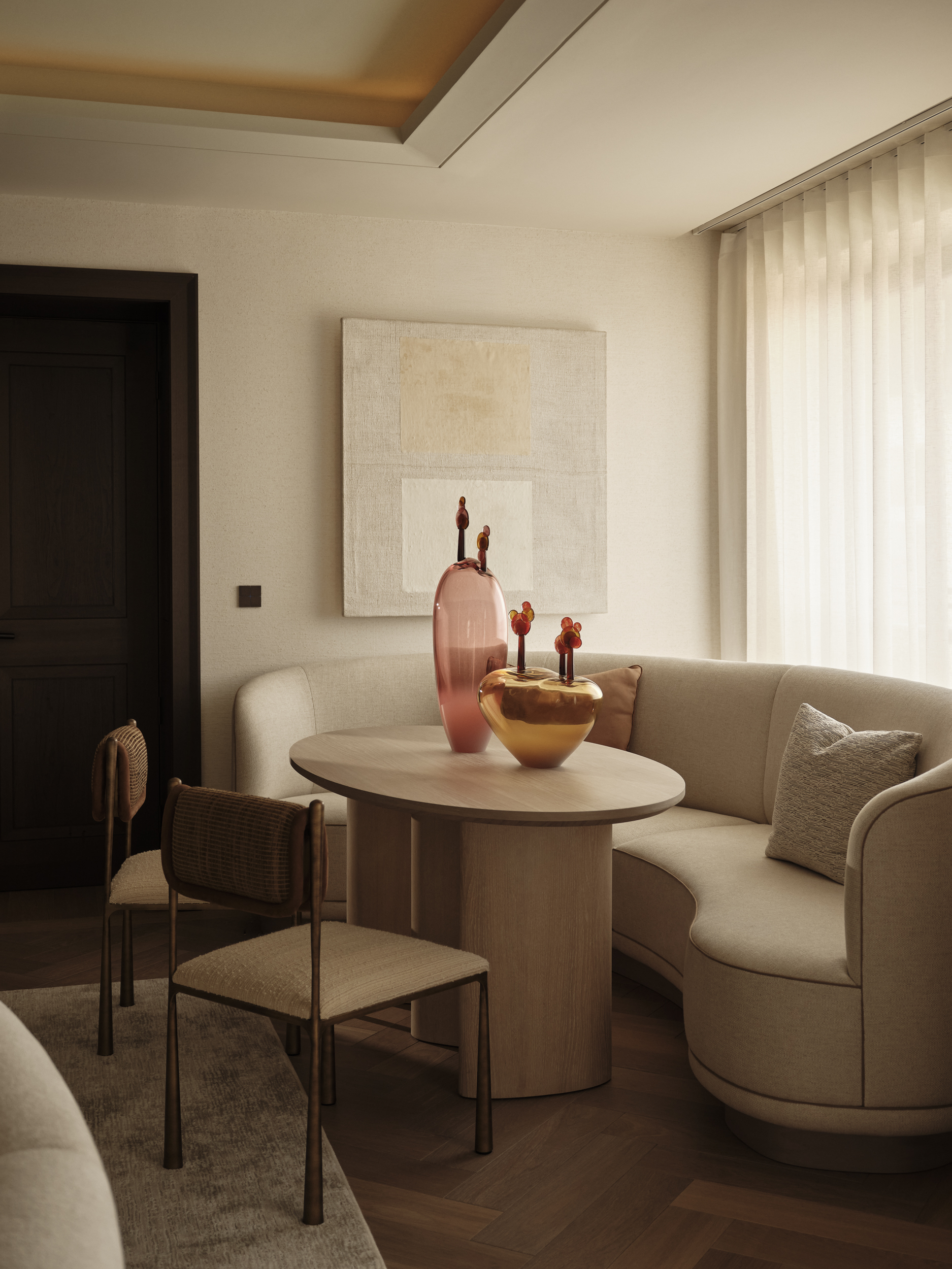 Curved upholstered banquette around a round pedestal table, paired with slender dining chairs beside a softly curtained window.