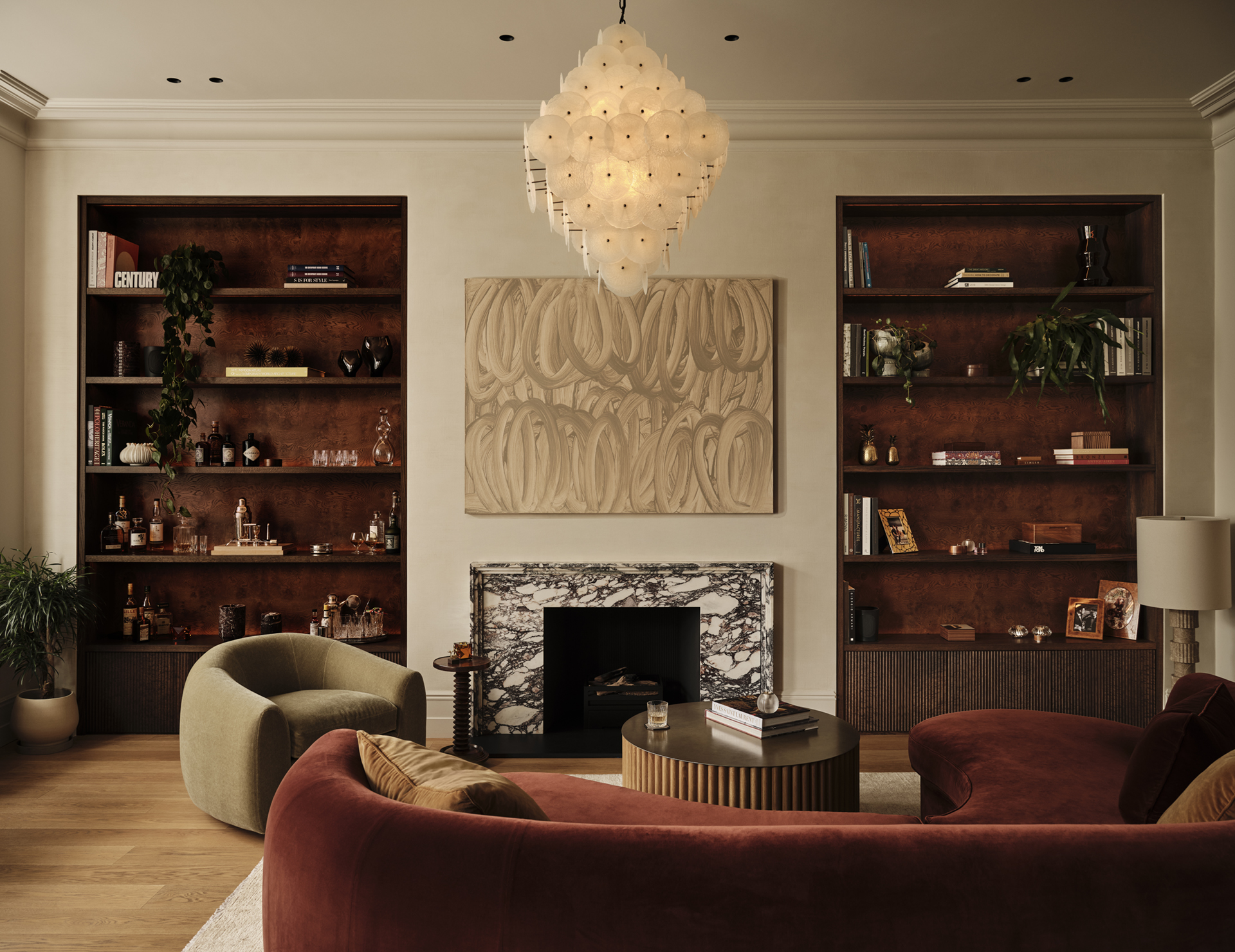 Stone fireplace framed by illuminated dark wood shelving, with sculptural artwork above and curved seating in the foreground, by Designed by Woulfe.