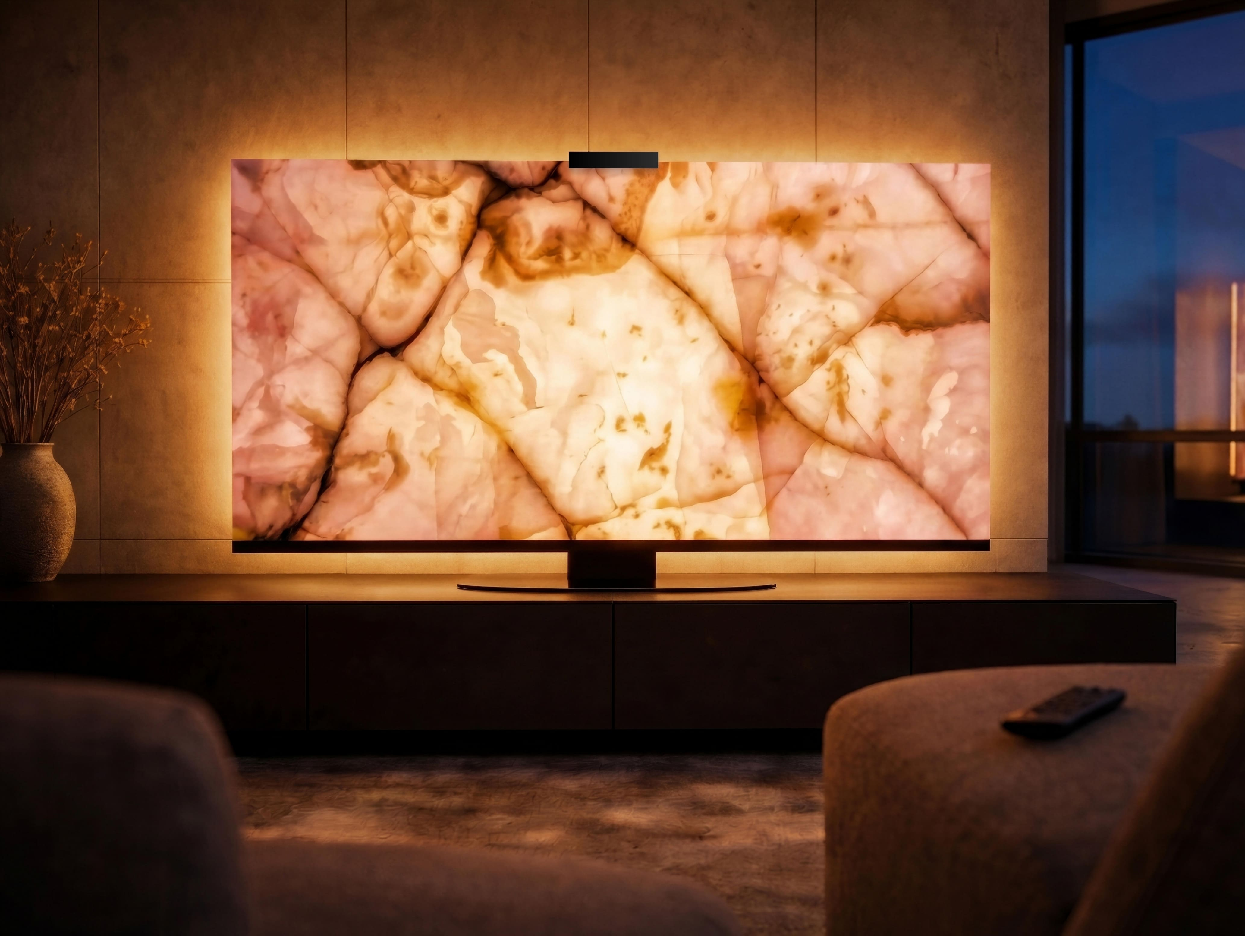 Pink Onyx Halo Screen at night in a modern living room, glowing with warm backlight through translucent blush and amber mineral layers.