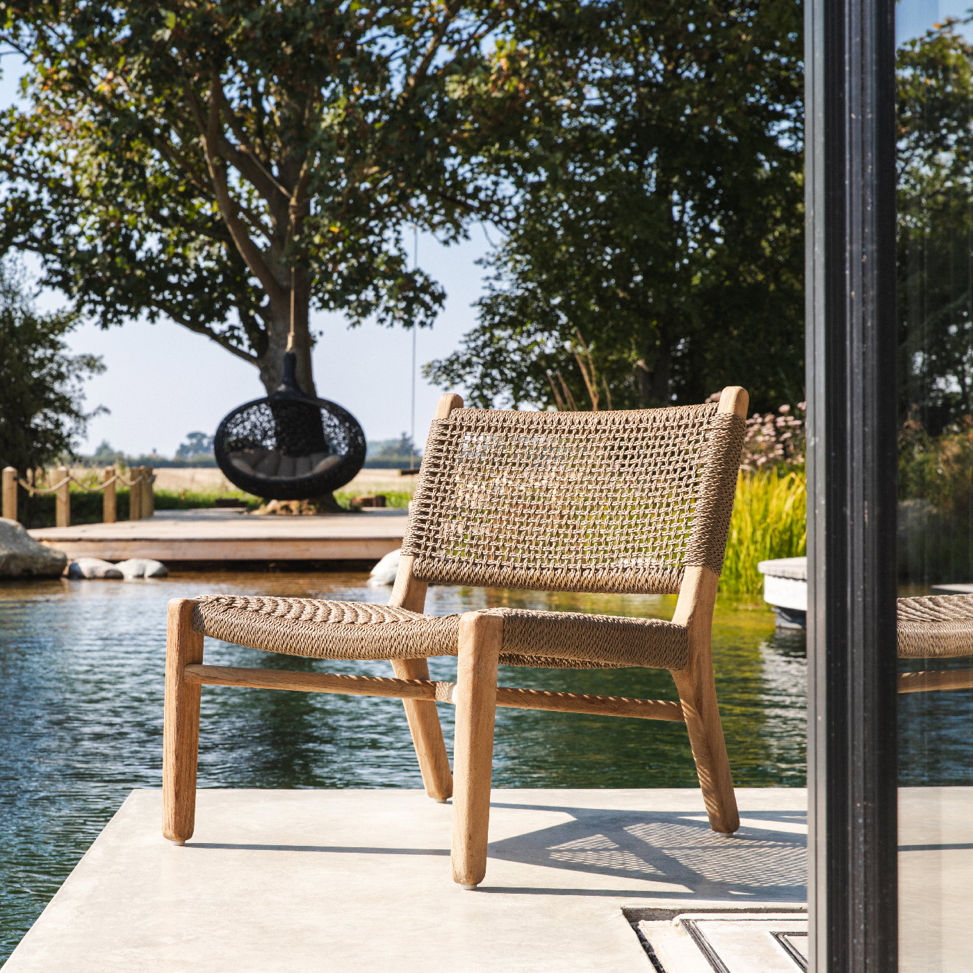 Image of Gommaire Fiona easy chair with natural swimming pool and Bios Hide pod in the background