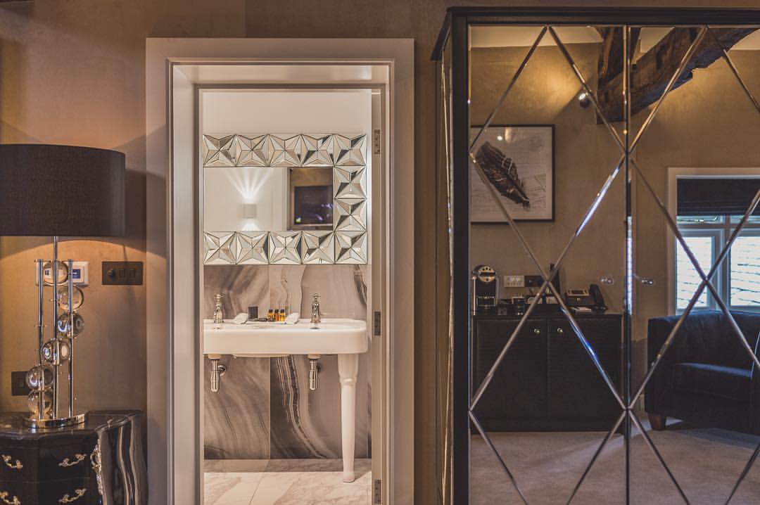 Moor Hall guest bedroom interior in Aughton, featuring a mirrored wardrobe, decorative artwork and contemporary furnishings.