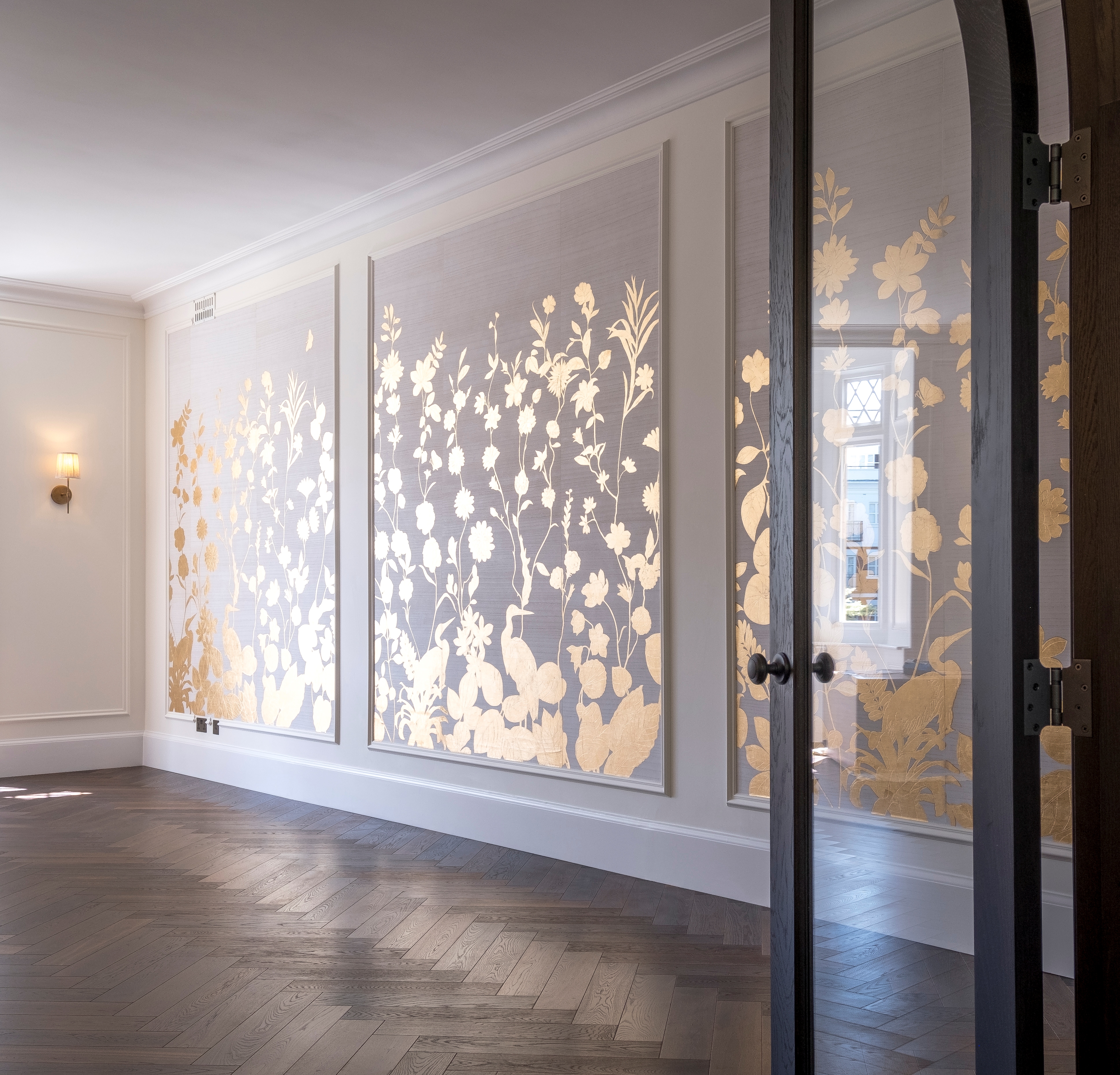 GBG photo of a renovated drawing room with installed herringbone flooring and gold leaf wallpaper  in Kensington W8.