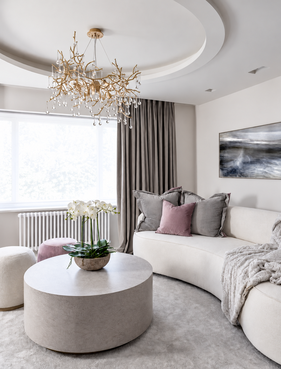 Curved bedroom sofa with velvet cushions beneath a gold and glass chandelier.