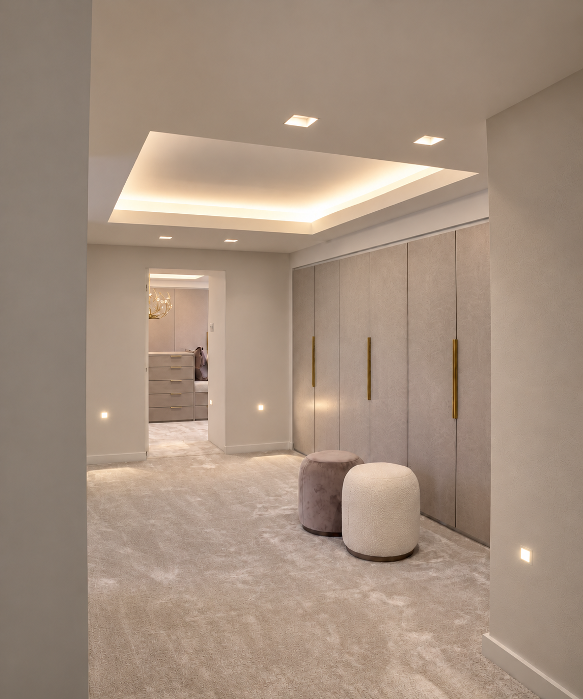 Dressing room with illuminated recessed ceiling, bespoke wardrobes and velvet footstools.