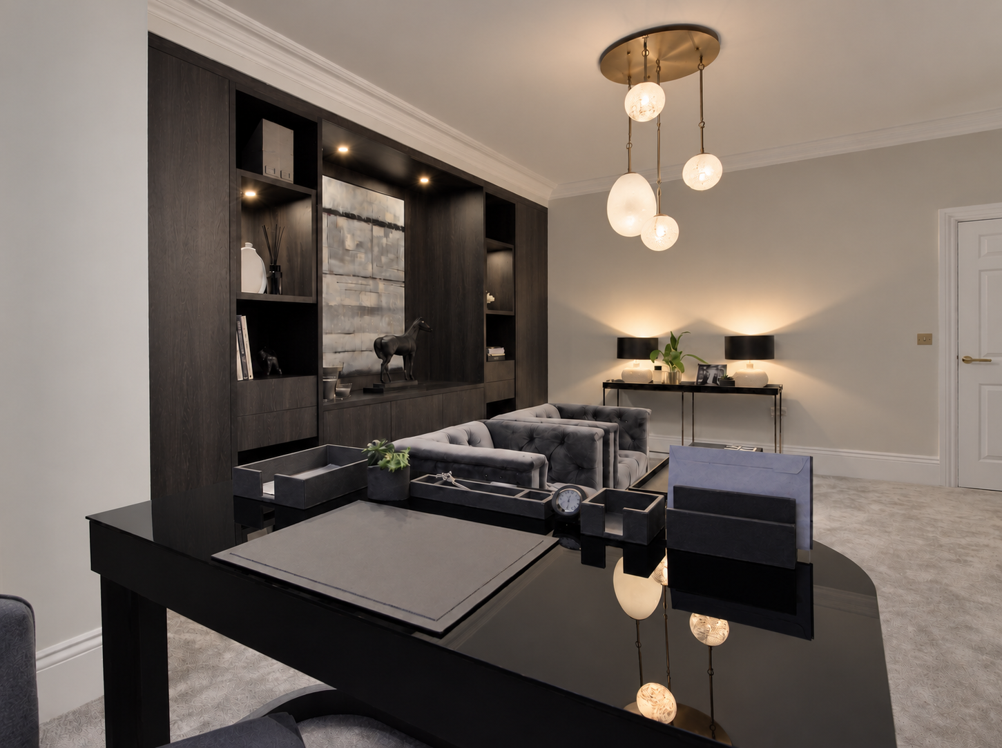 Bespoke home study with dark oak cabinetry and buttoned armchairs.