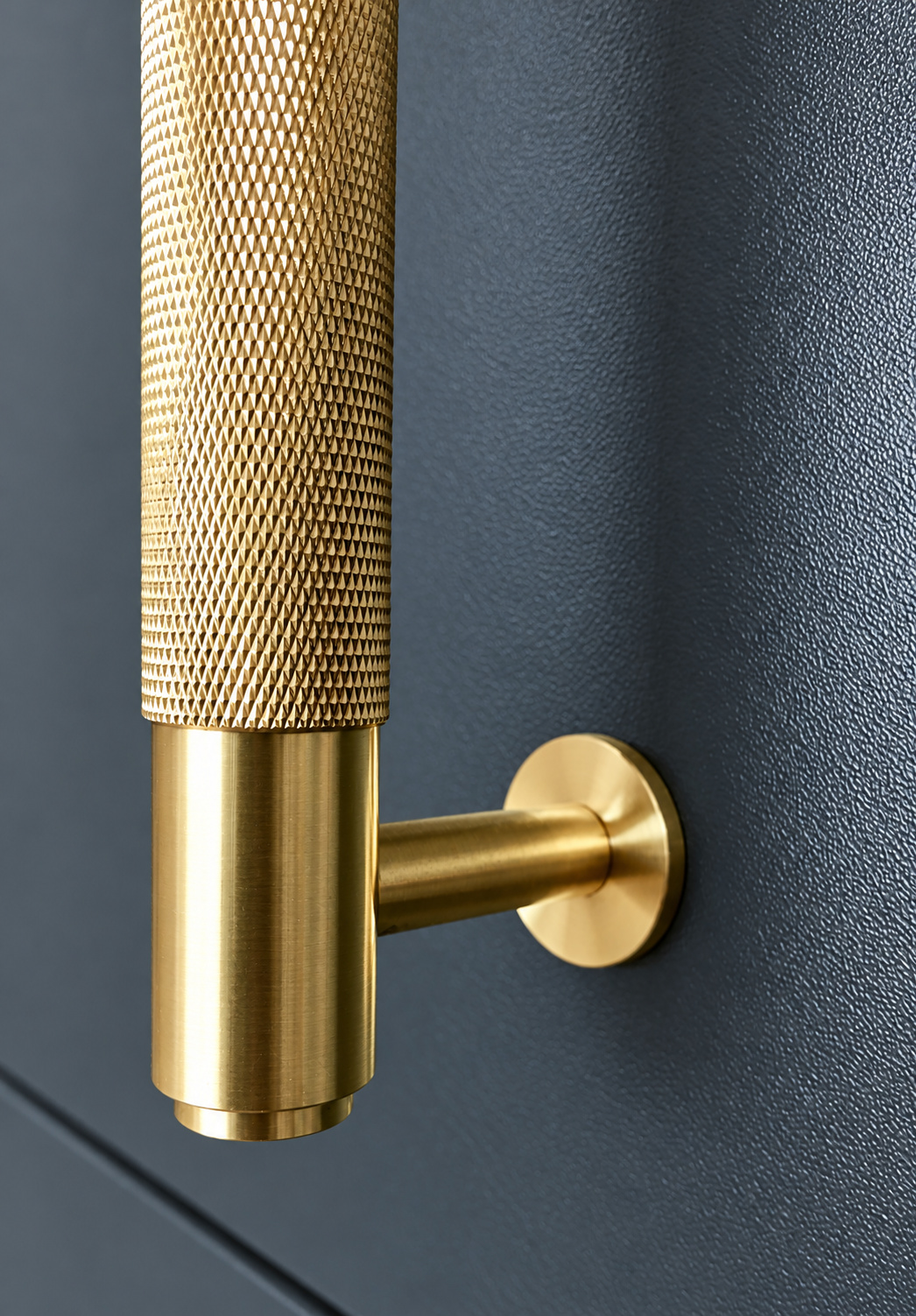 Close-up of a knurled brass kitchen handle against a dark cabinet door at The Upton, Prestbury.