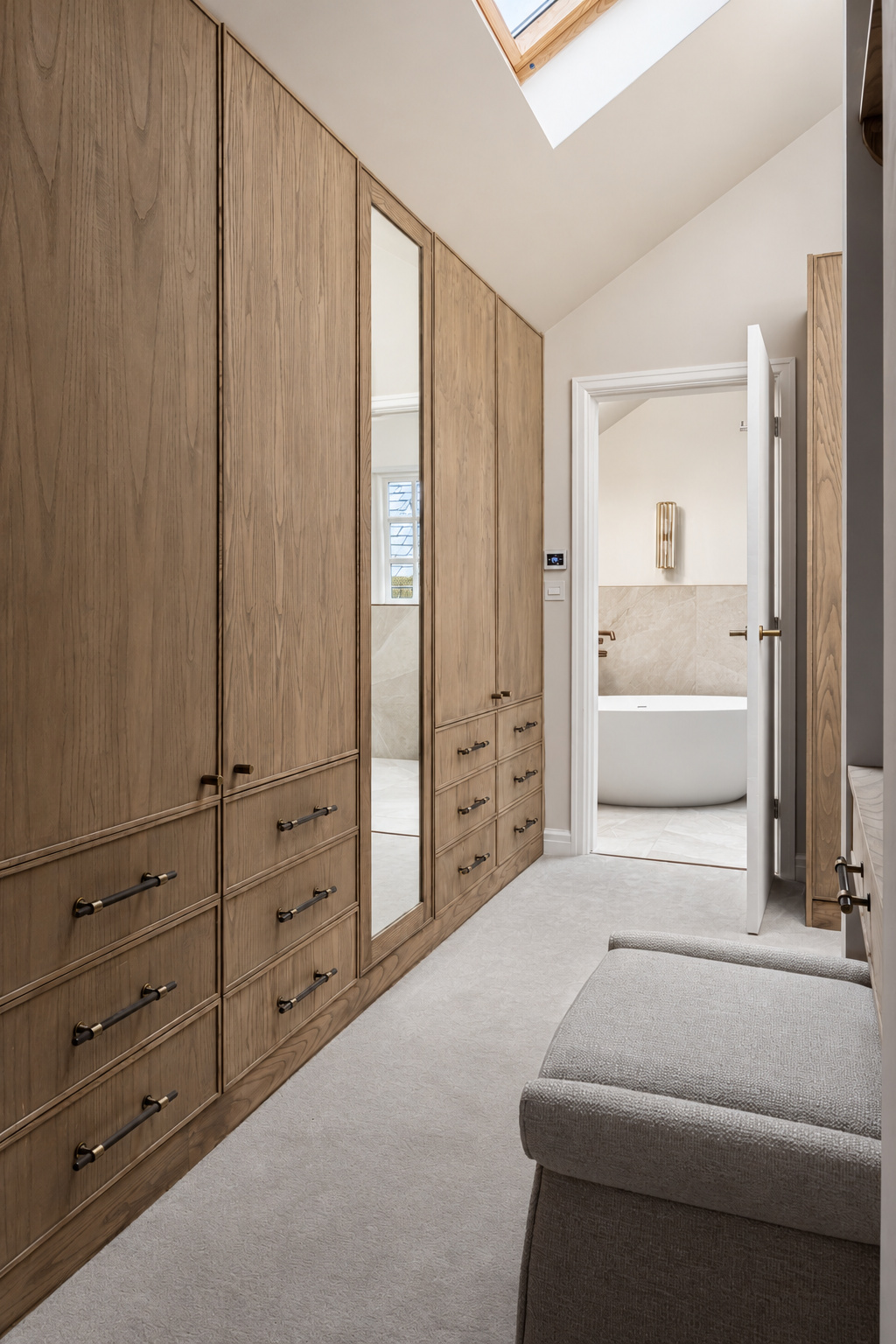 Fitted timber wardrobes and a full-length mirror beneath a dressing-room skylight at The Vault, Alderley Edge.