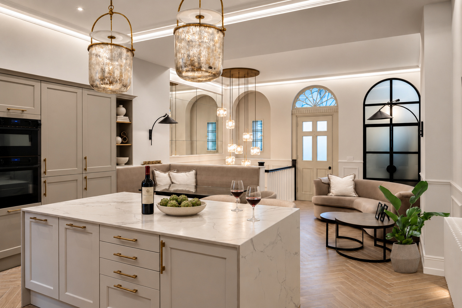 Kitchen island, glass pendants and curved sofa in the open-plan interior at The Vault, Alderley Edge.