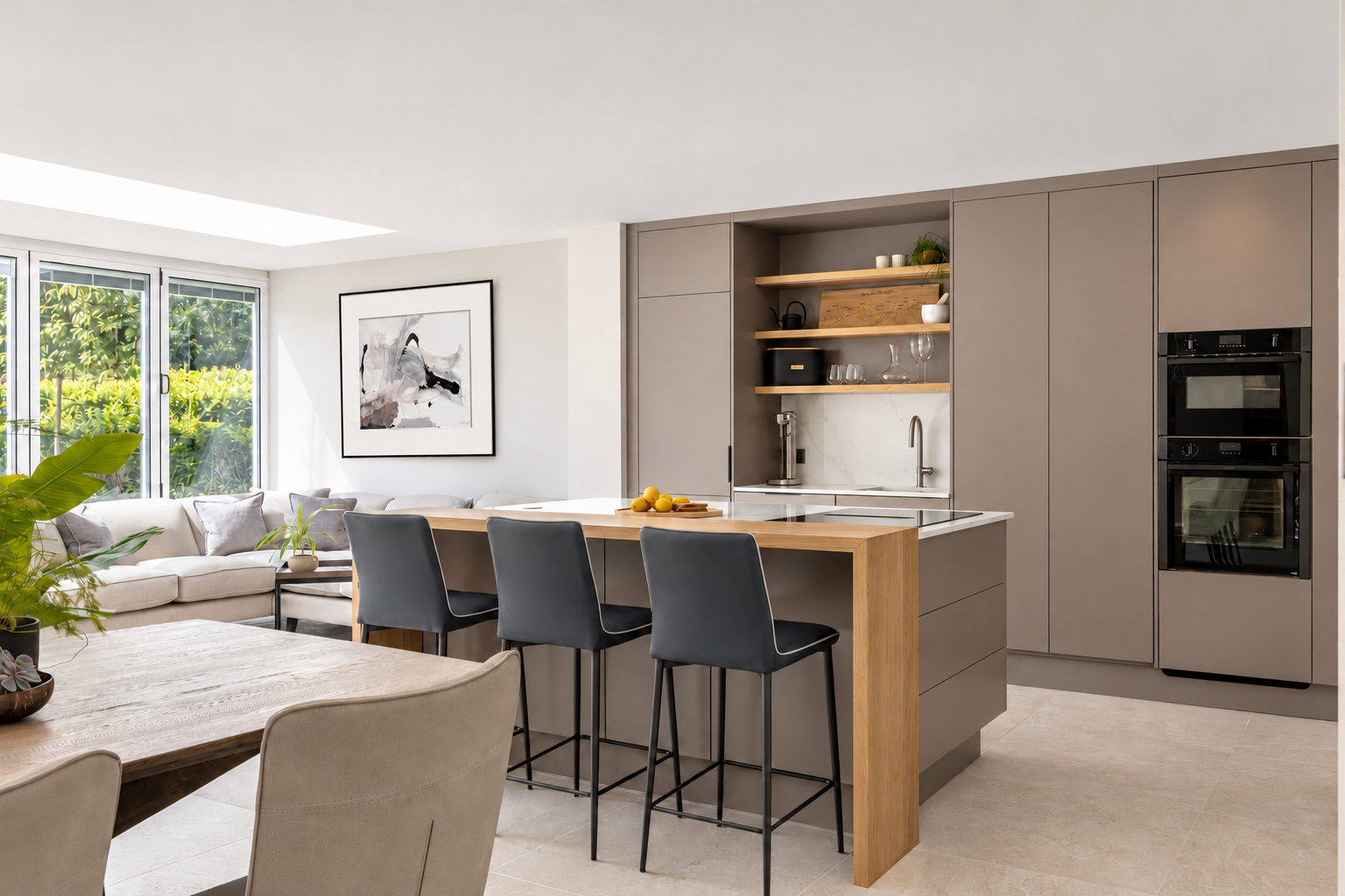 Bespoke taupe kitchen with an oak breakfast bar, three dark stools and open shelving at The Willows, Prestbury.