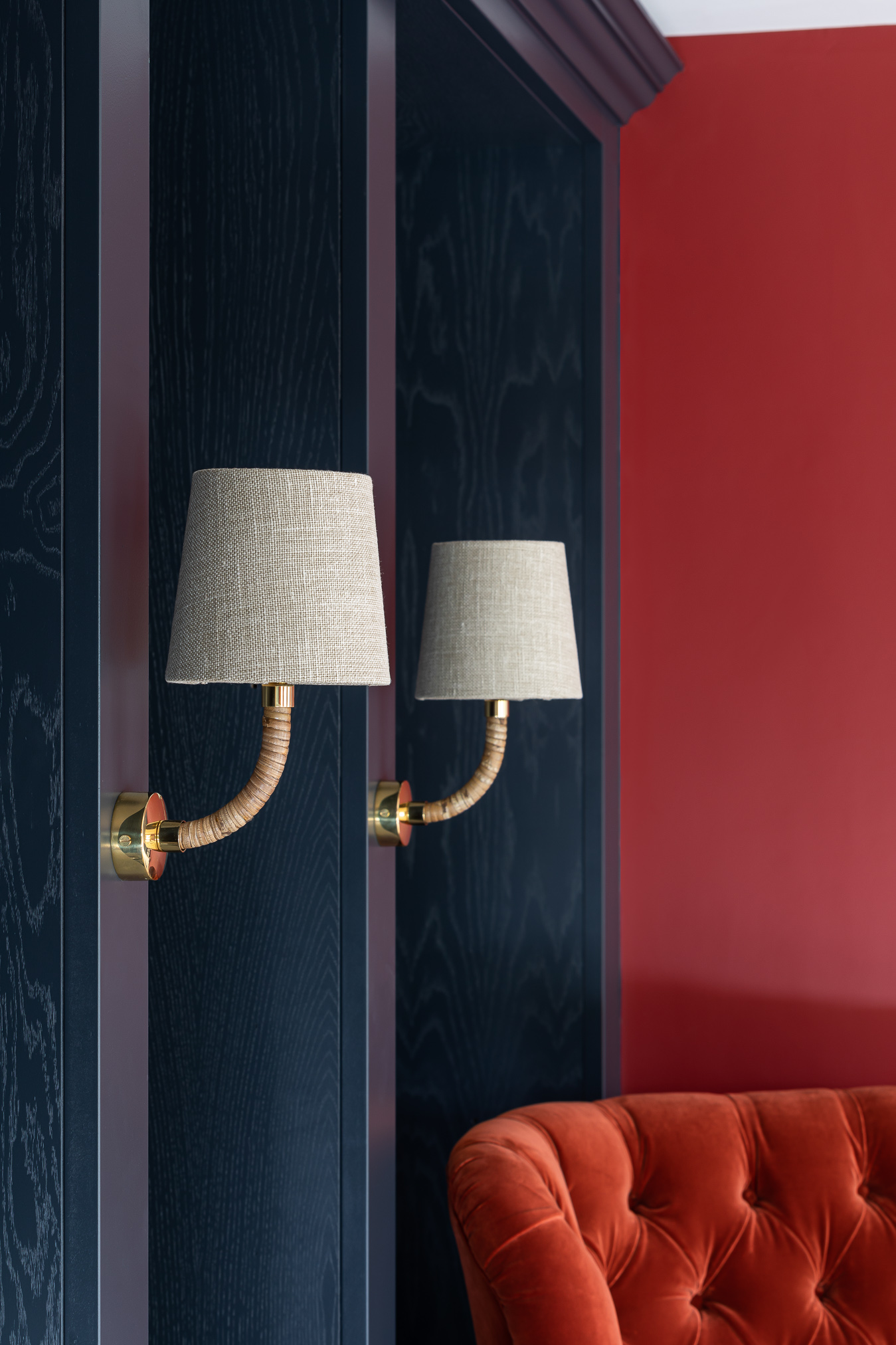 Dark bookcase joinery Porta romana wall lights red velvet chair and walls