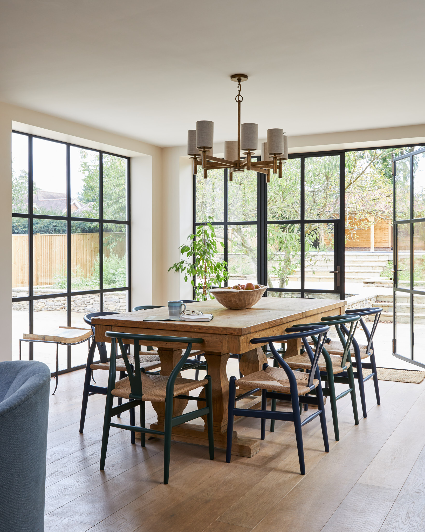 Kitchen table with wishbone chairs and crittal windows and doors.  Porta Romana pendant