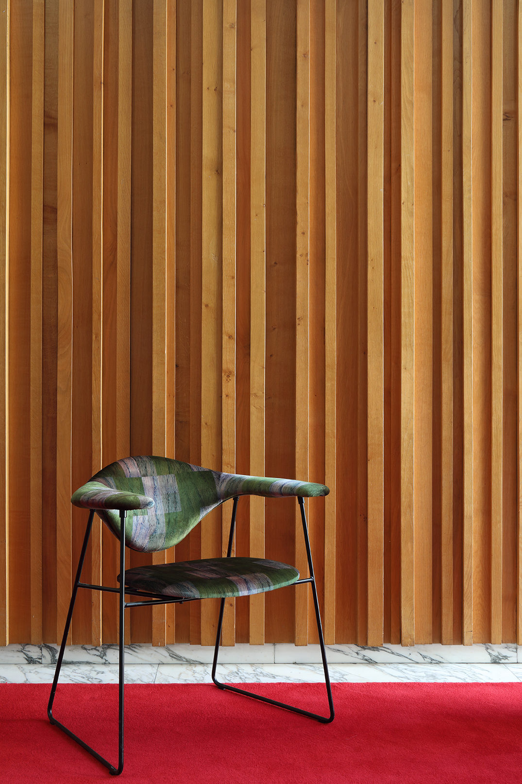 Classic Gubi chair in front of 1960s panelling
