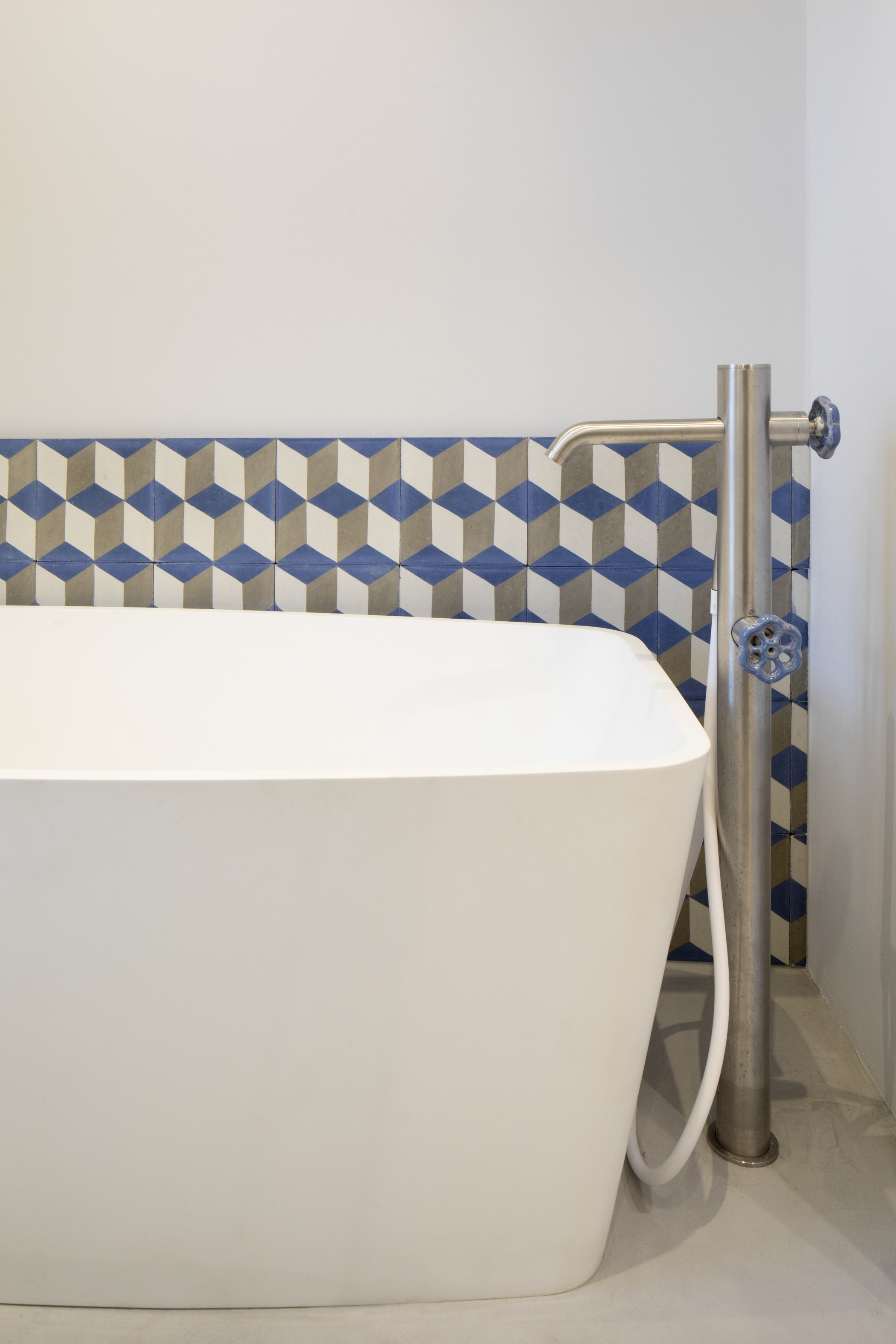 Bathroom with patterned feature tiles behind the bathtub