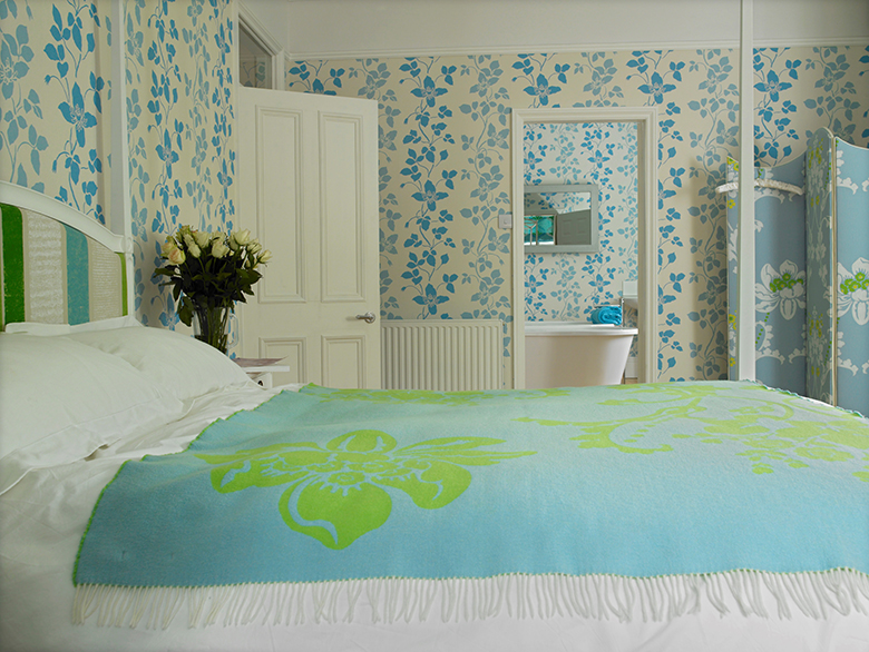 A fun, vibrant and very comfortable simple guest room and en-suite, with contemporary four poster and side-by-side bathing