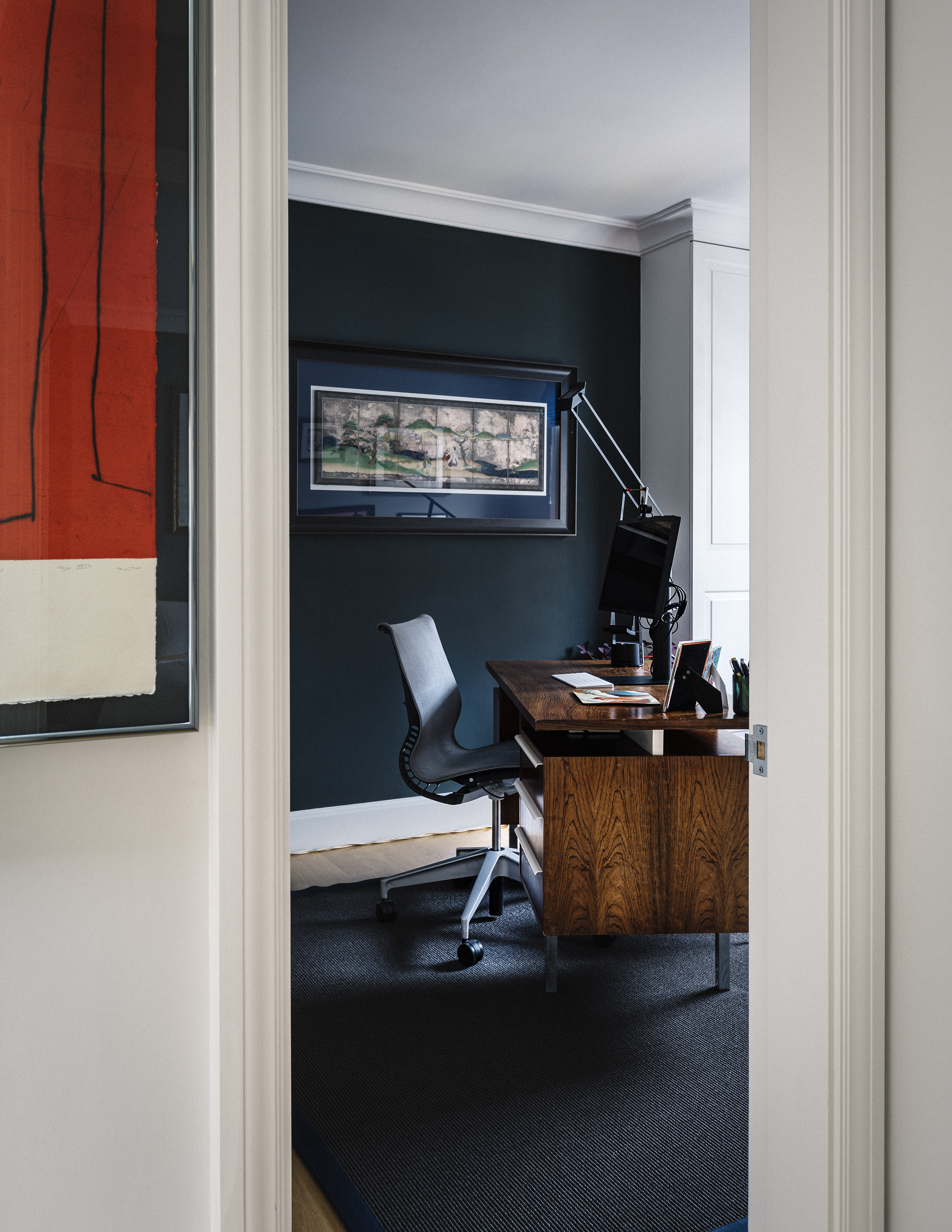 Deep blues and greens set off the glossy Mid-Century Modern desk in this home office