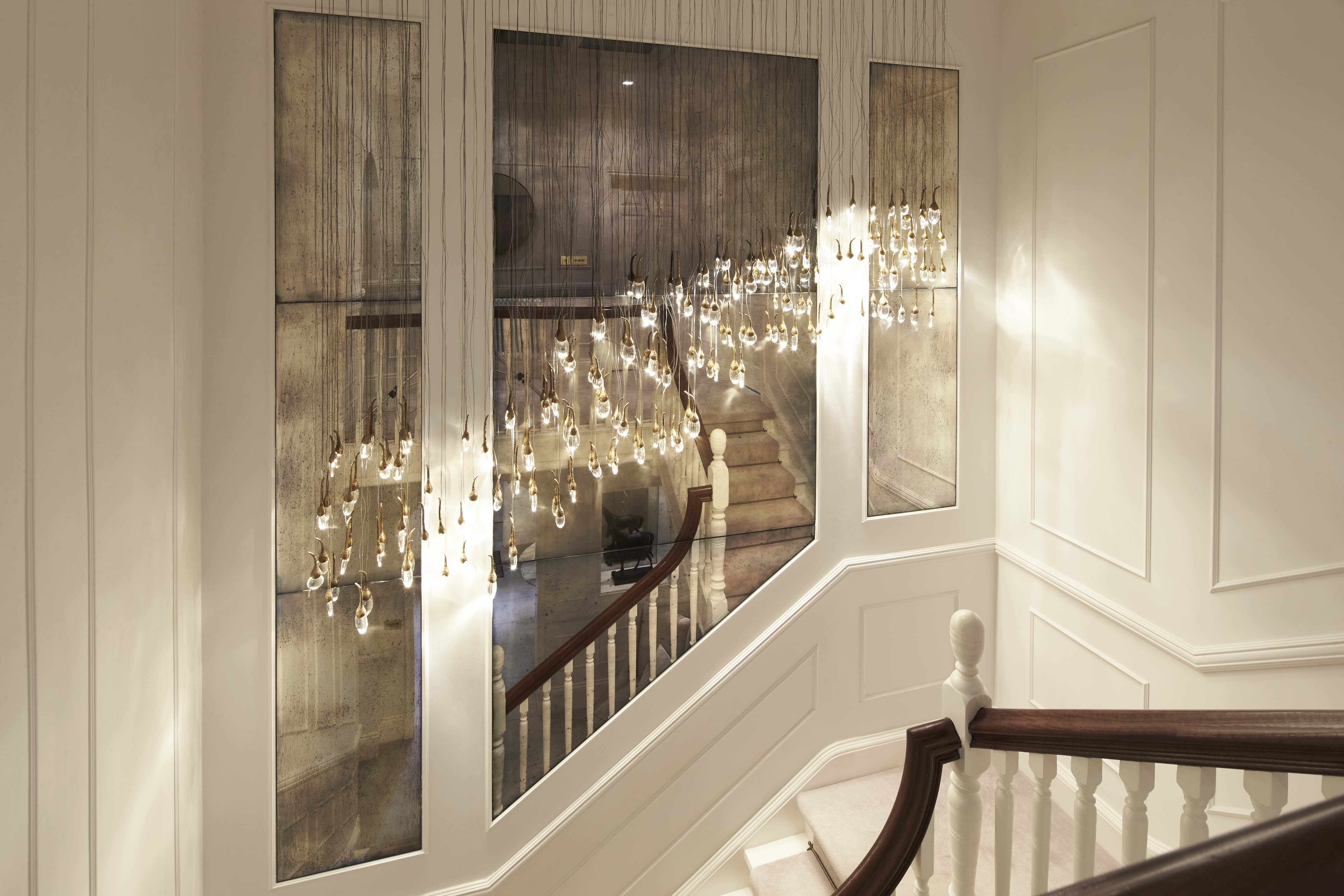 Antique mirror wall paneling above staircase 